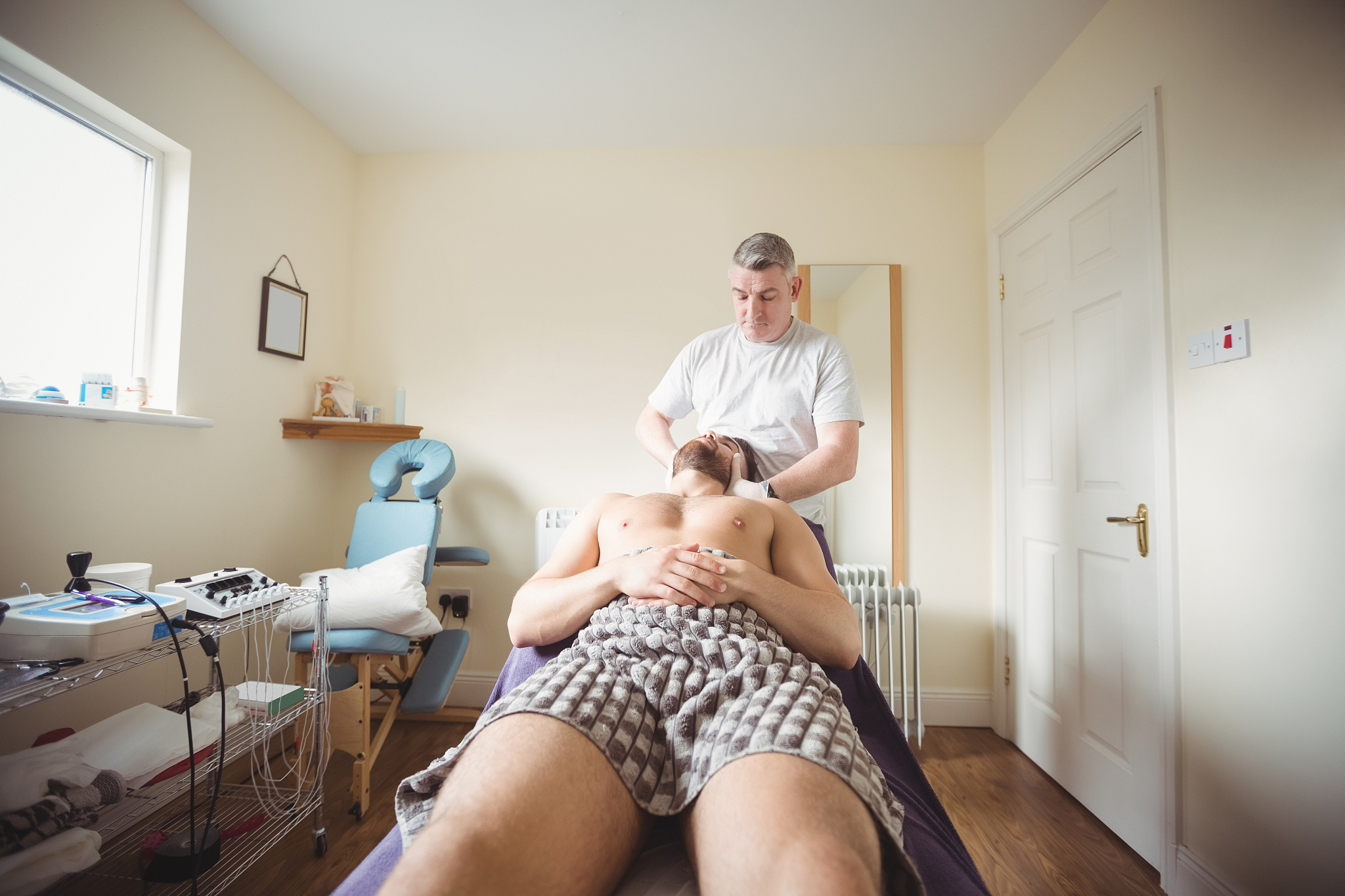 physiotherapist examining neck of a patient