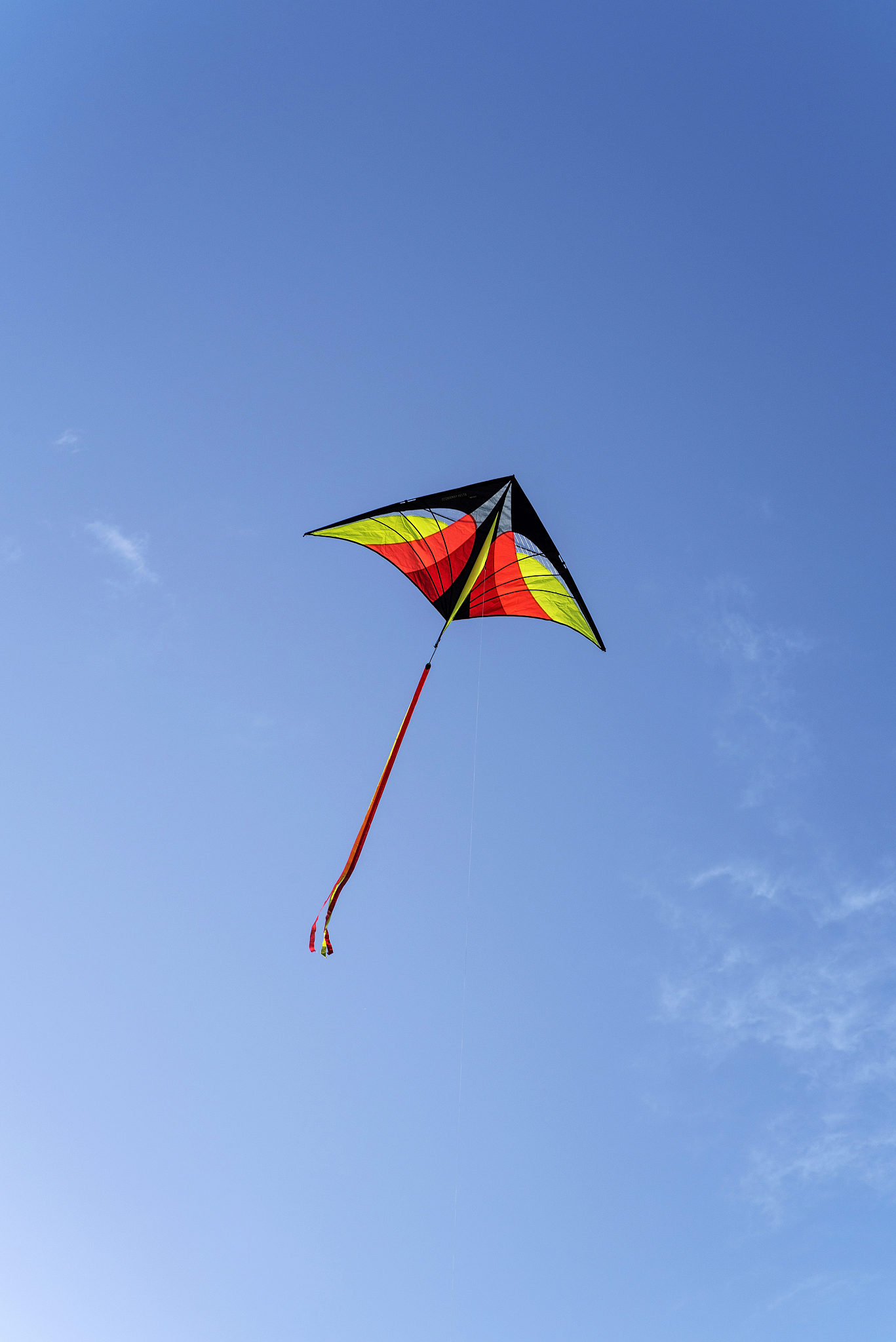 colorful kite is flying in a blue sky