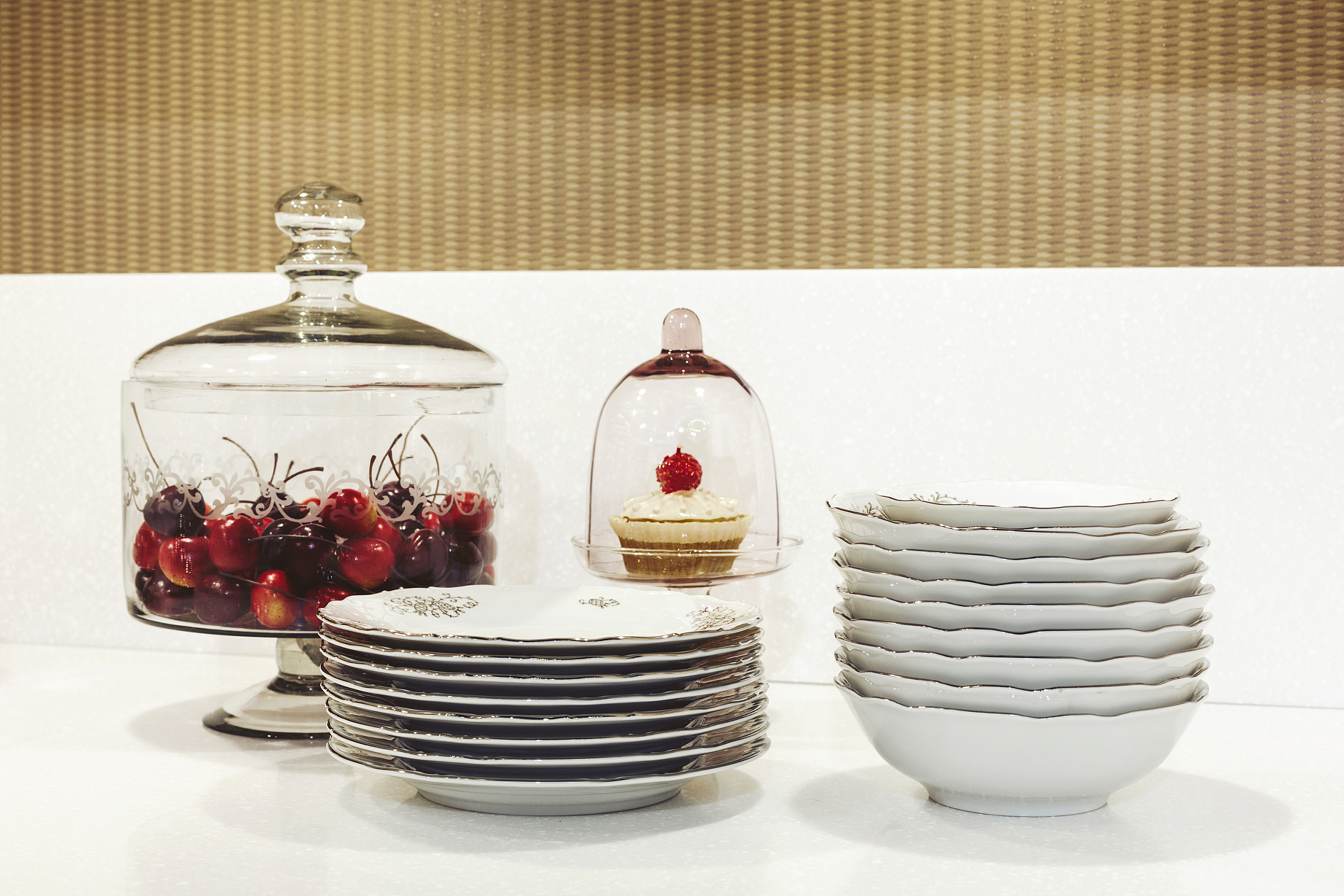 kitchen table with white plates, vase of cherry and cake under g
