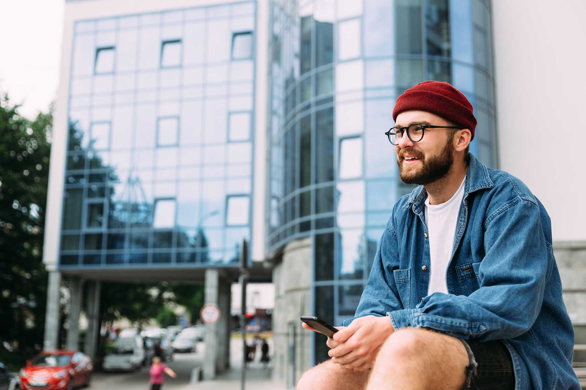 cheerful bearded hipster male relaxed sitting in the city, holdi