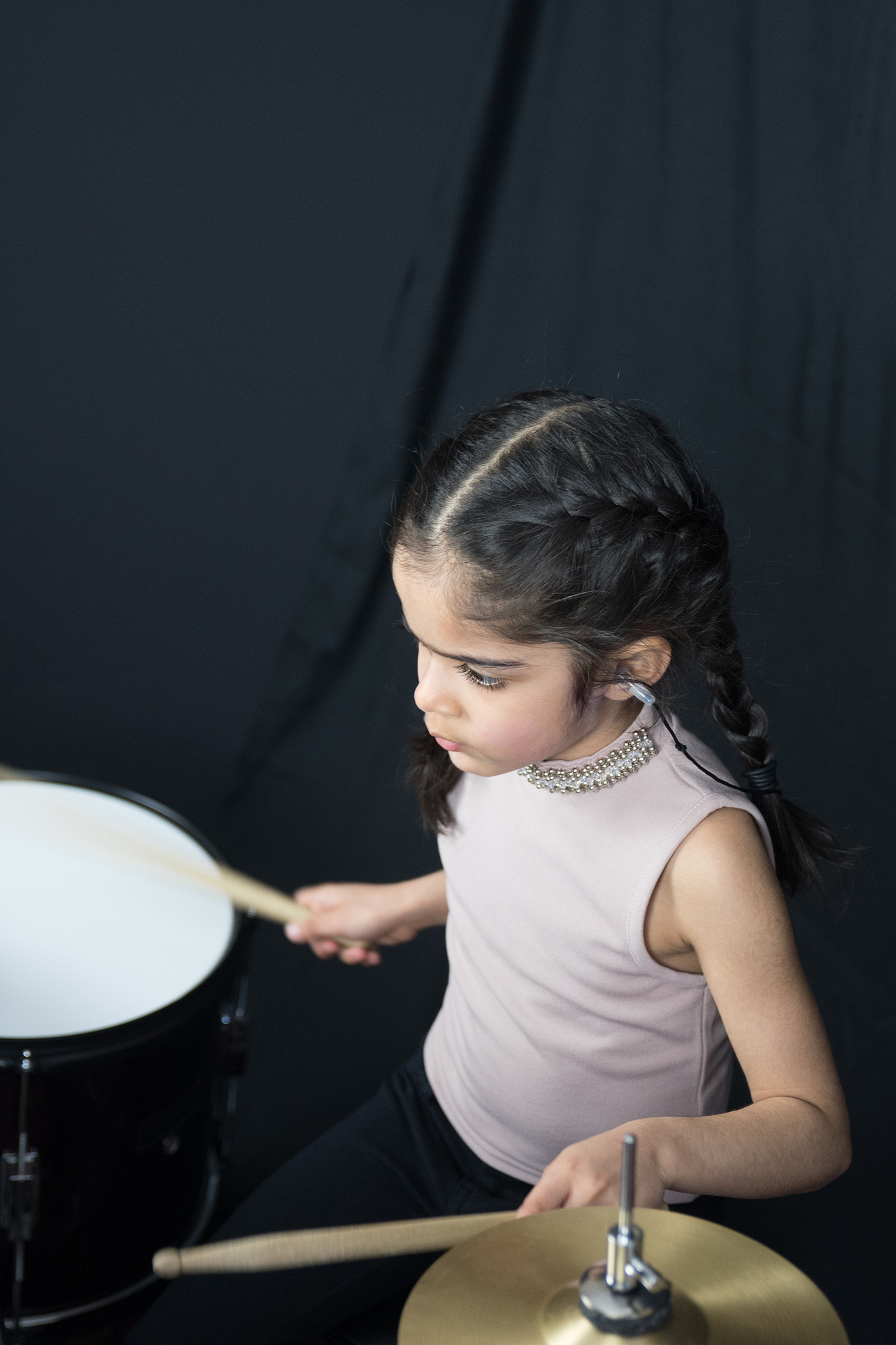 5 year old girl practices the drums