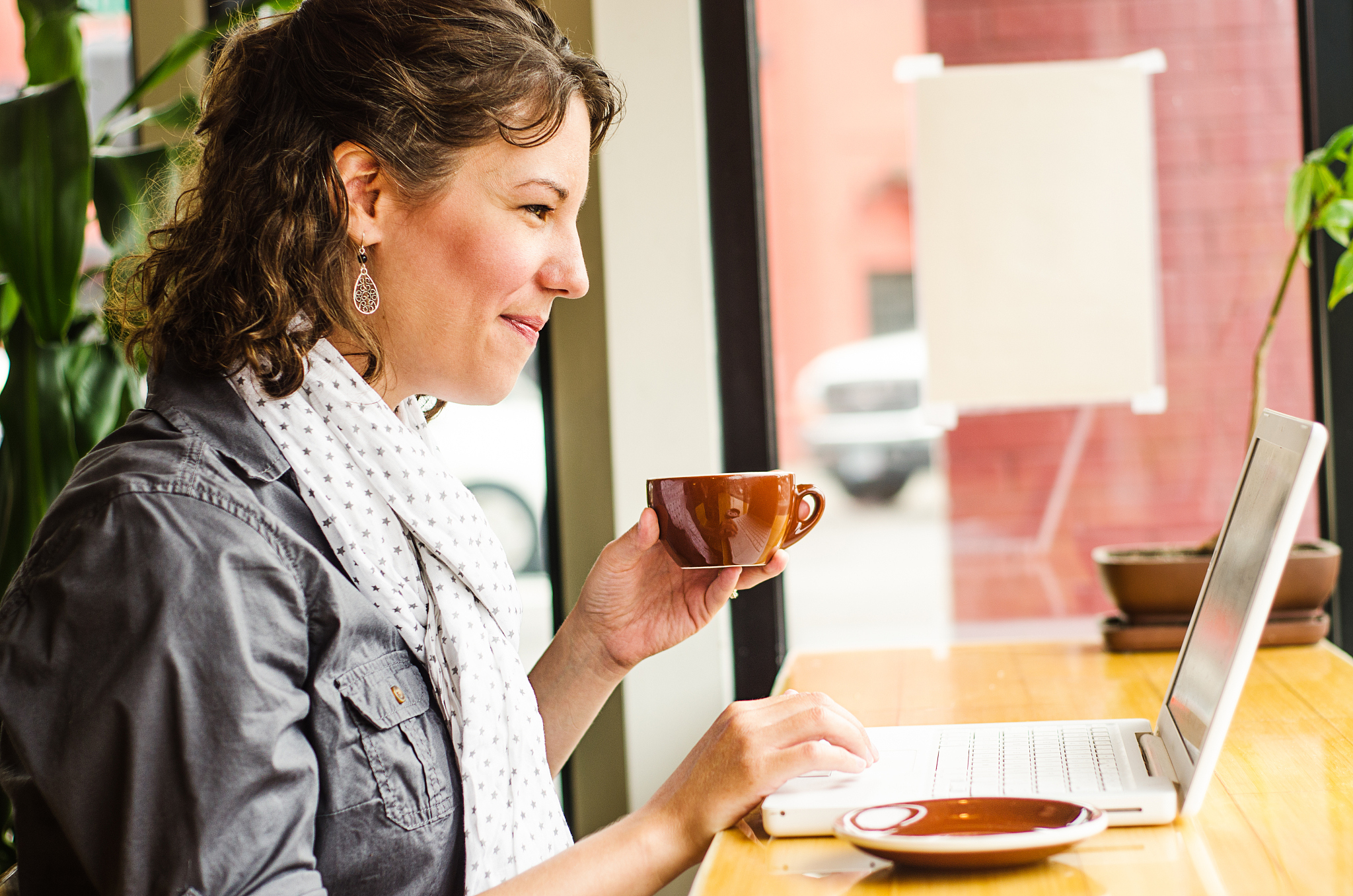 woman working on her laptop in a coffee shop