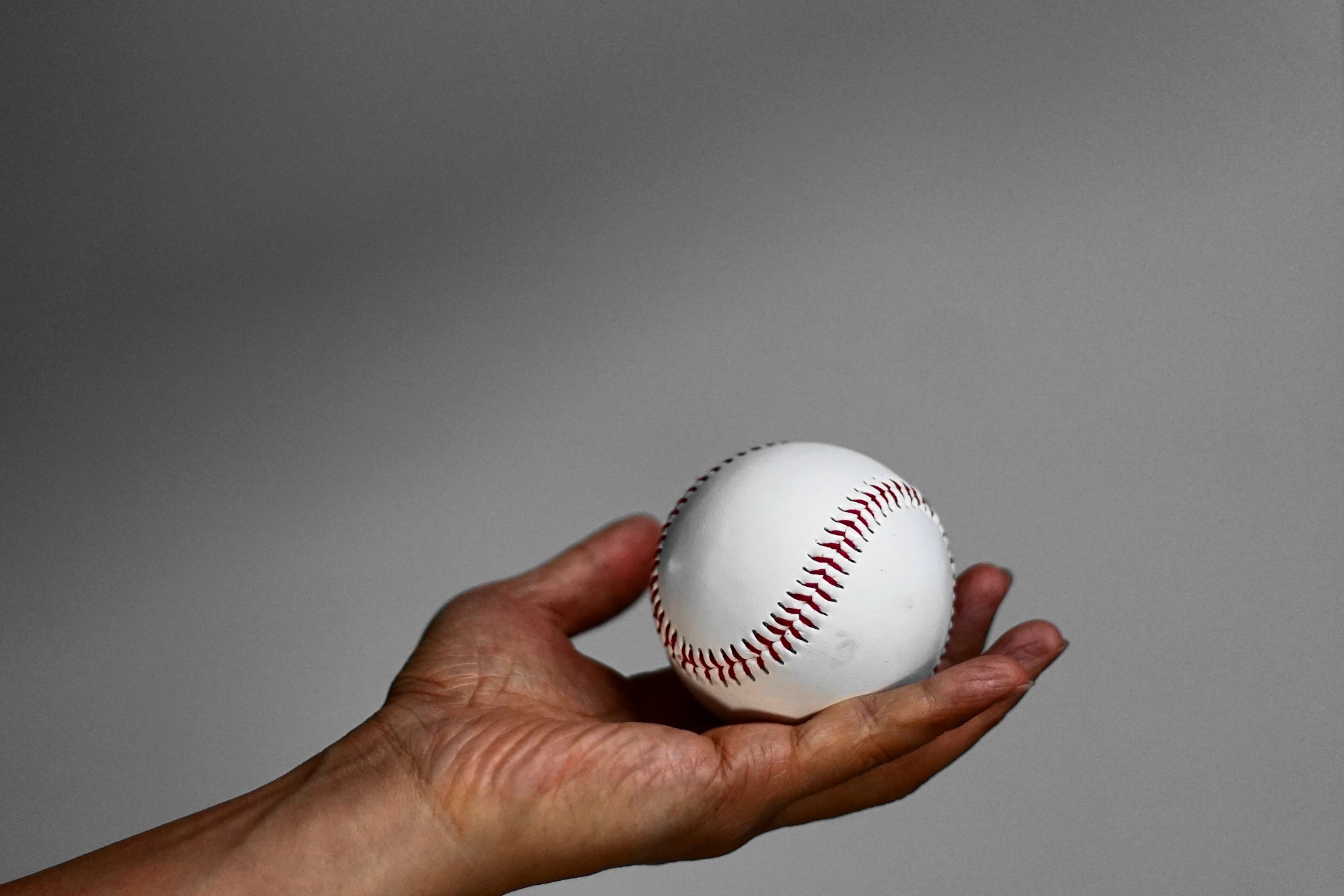a hand grasping a baseball in various poses