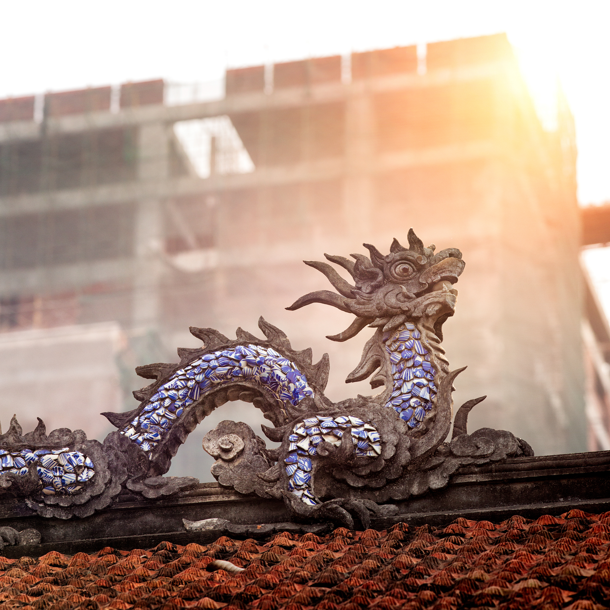 sculpted traditional vietnamese dragon on roof with modern const