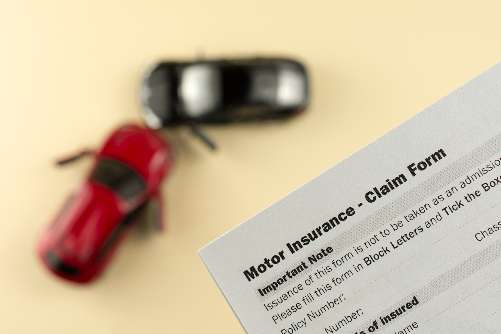 two broken cars and car insurance document