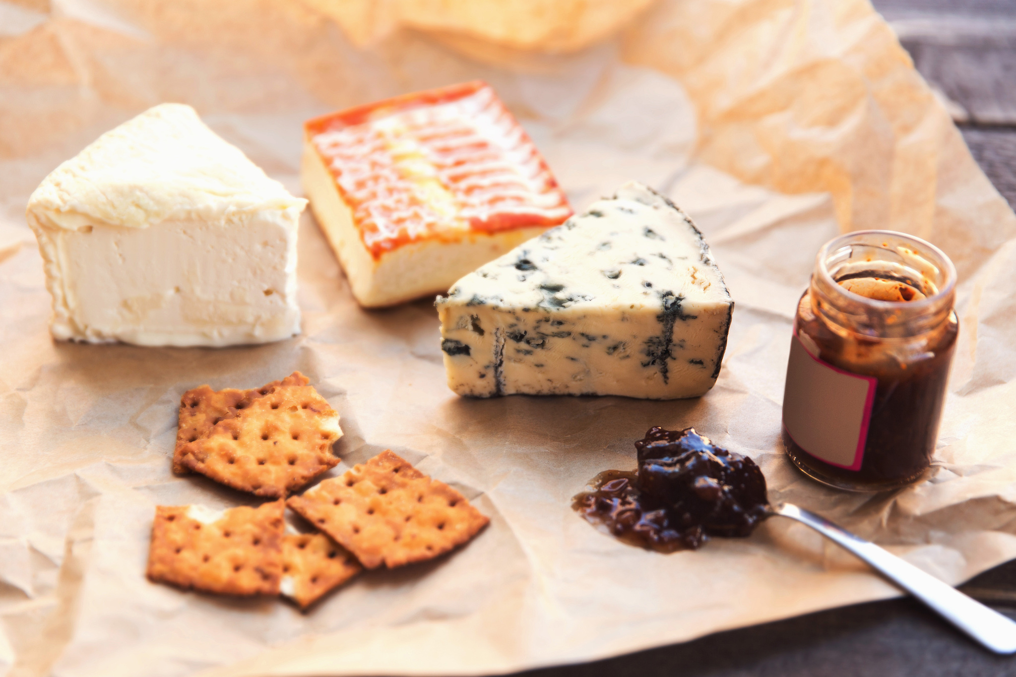 cheese with crackers and preserves on table