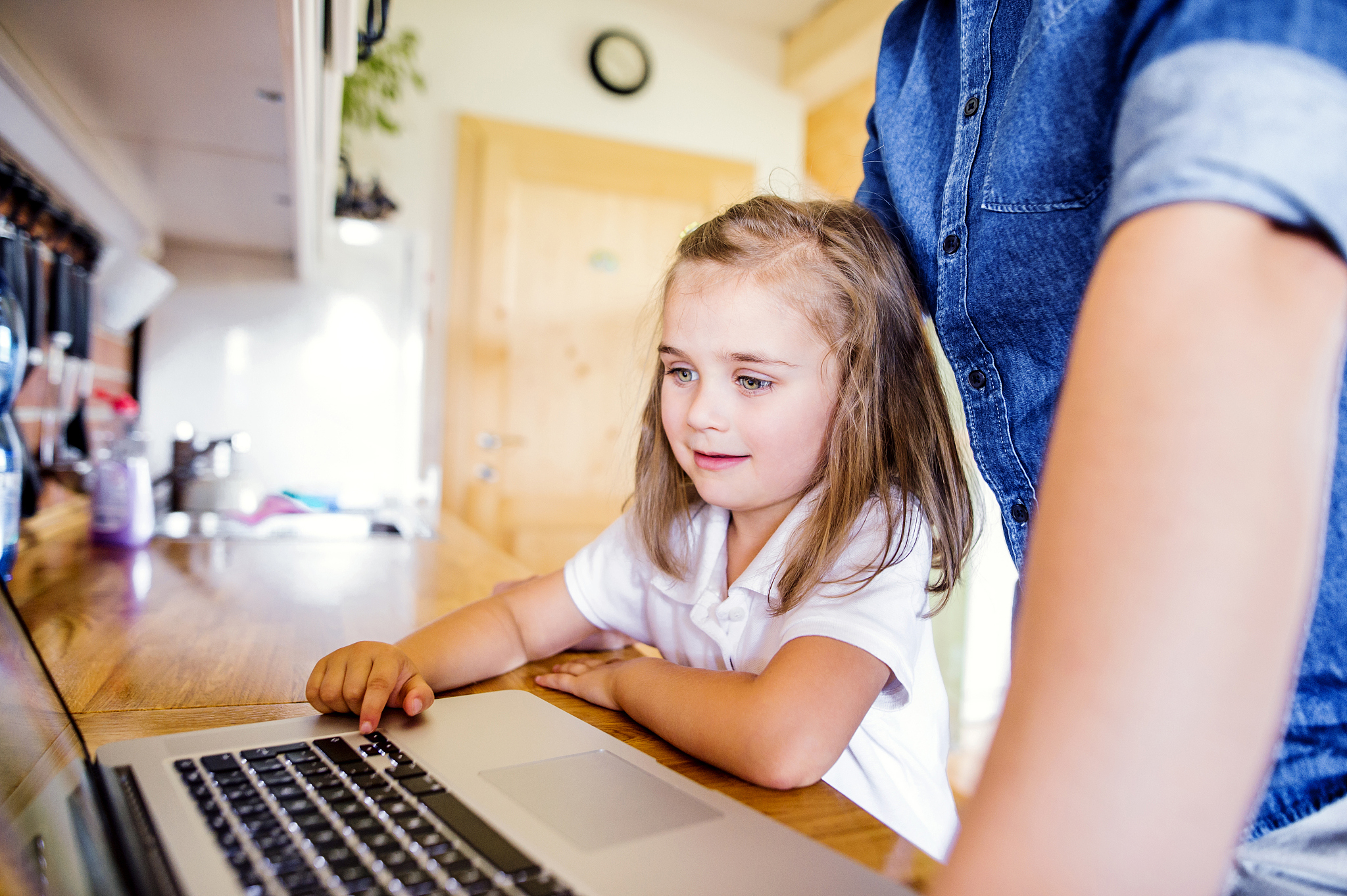 father and daughter using laptop at home