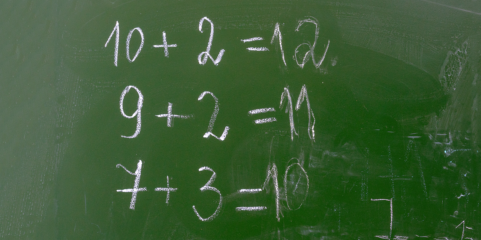 algebra lesson in primary school numbers on green chalkboard