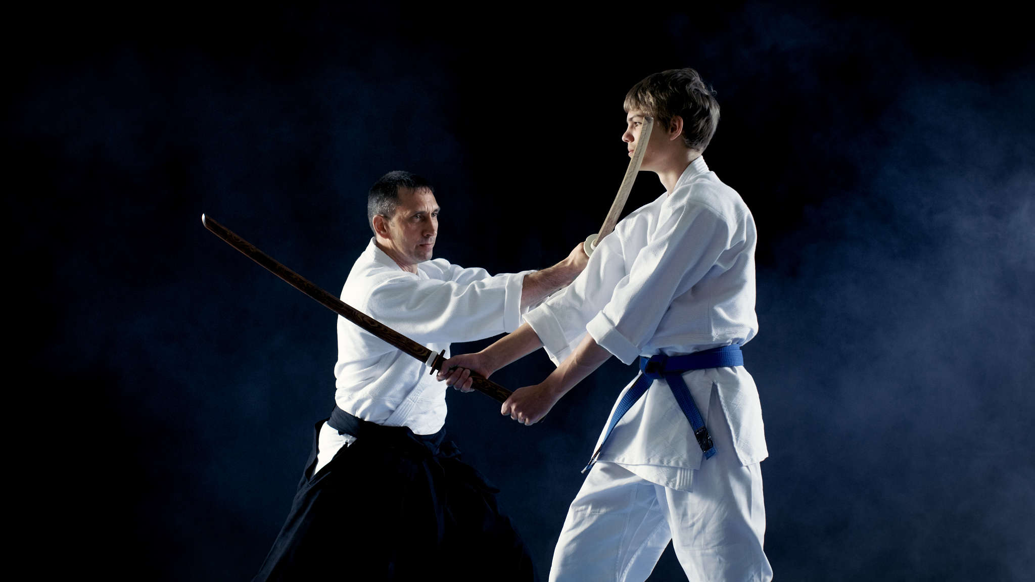 martial arts master teaches his young student how to fight with 