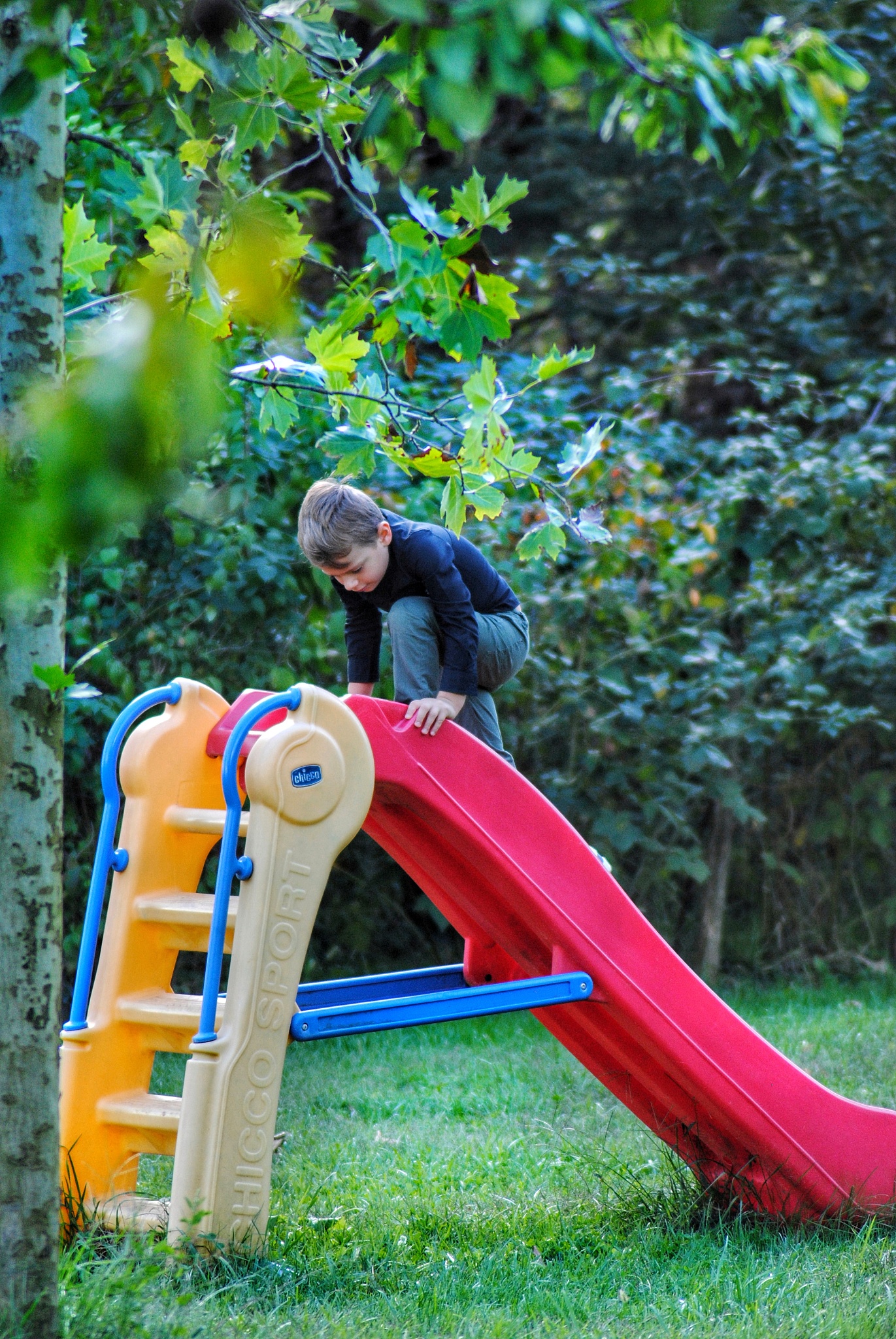 rear view of a baby boy on slide at park