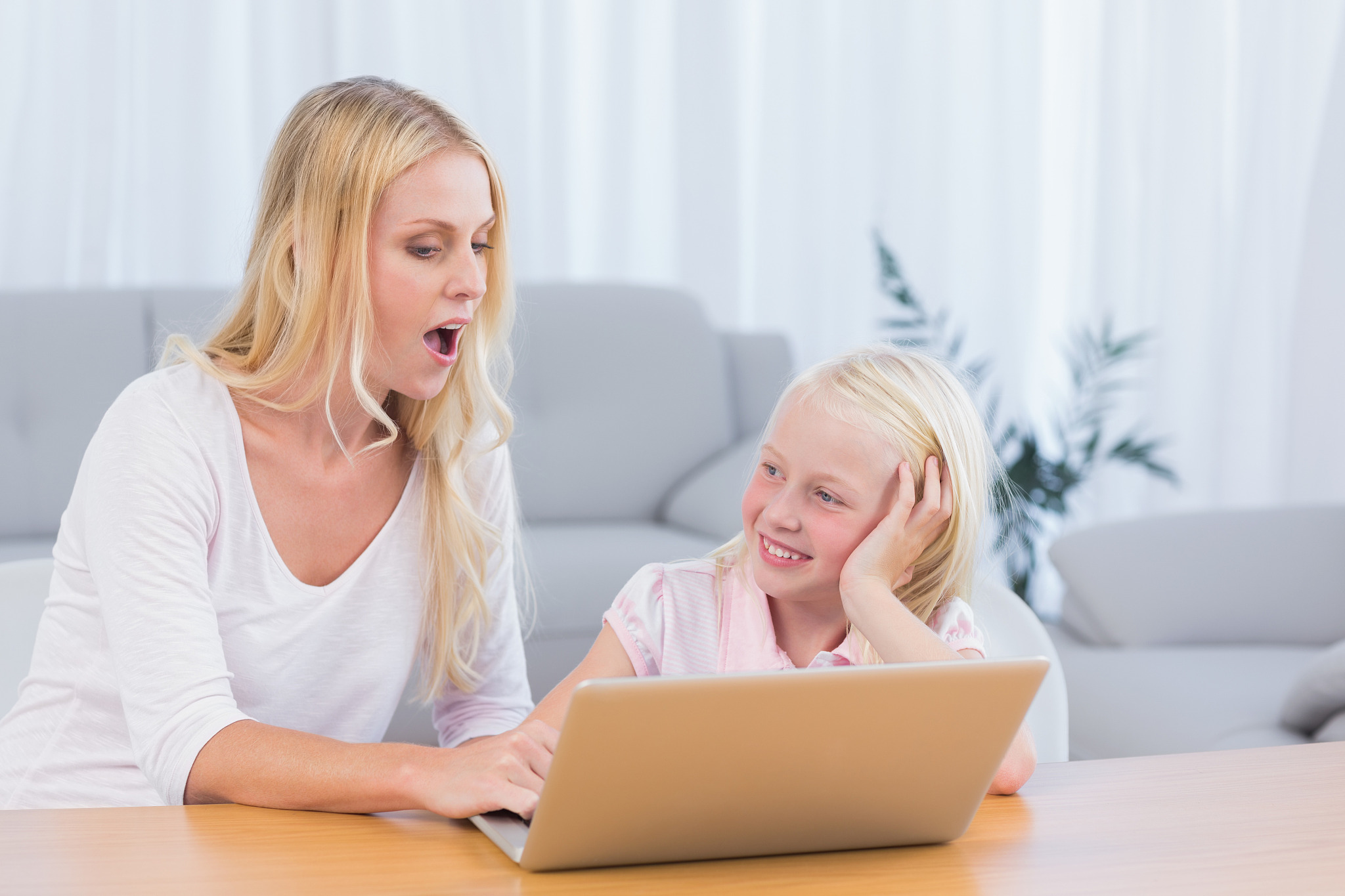 mother and daughter using laptop in the living room