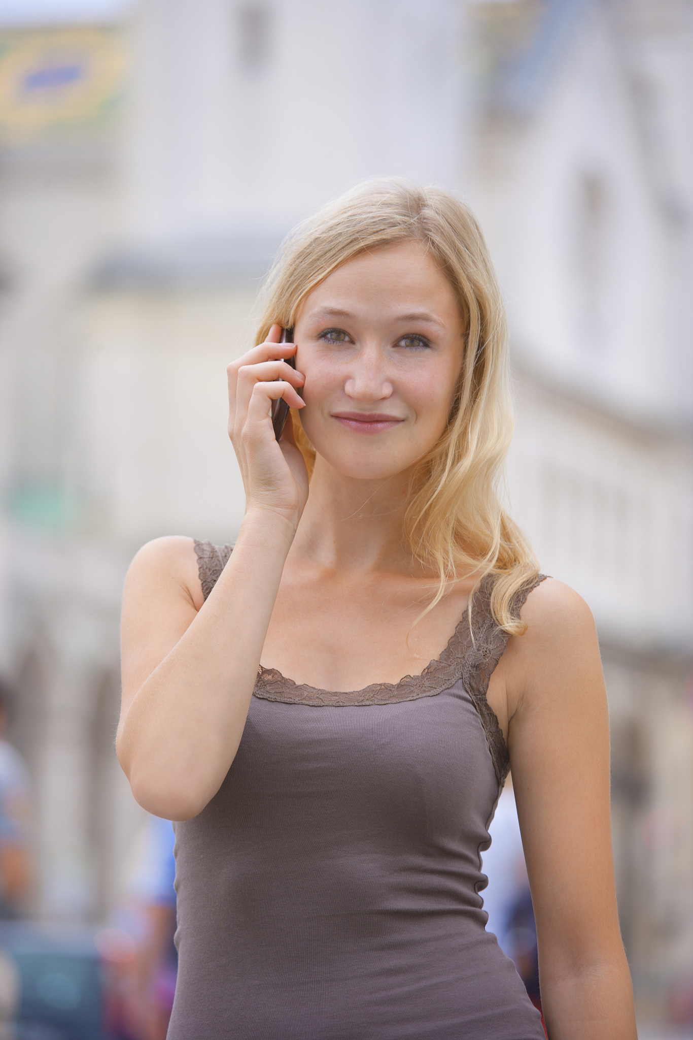 germany, bavaria, munich, young woman talking on phone in front 