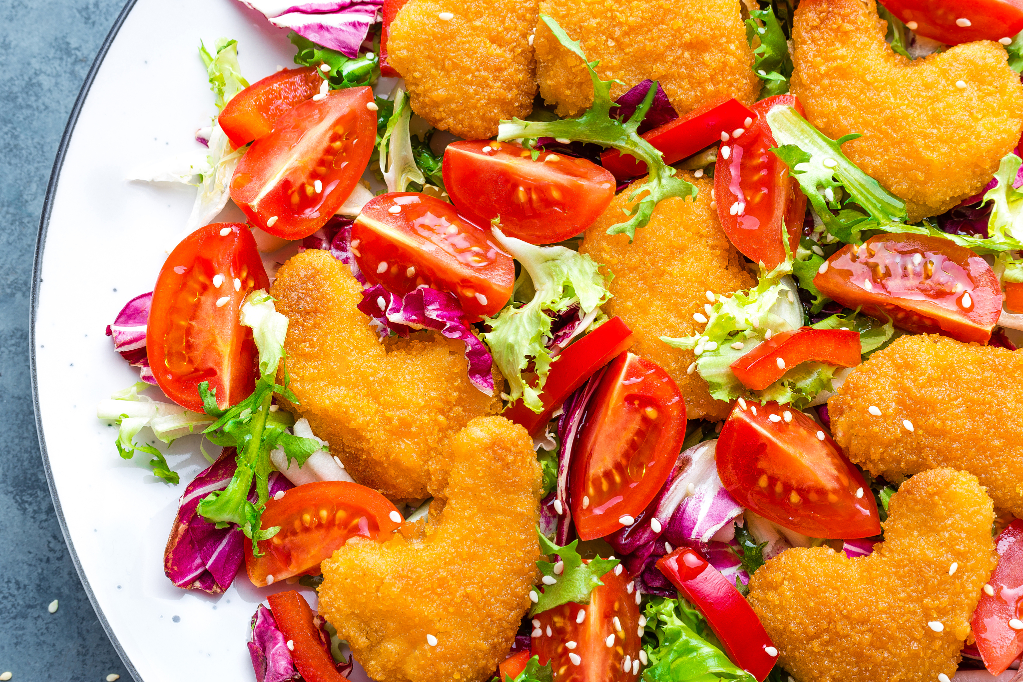 chicken nuggets with salad. fresh vegetable salad of tomatoes, l