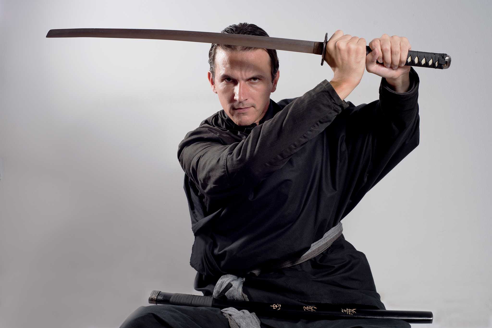 man dressed as a samurai holding katana in the air