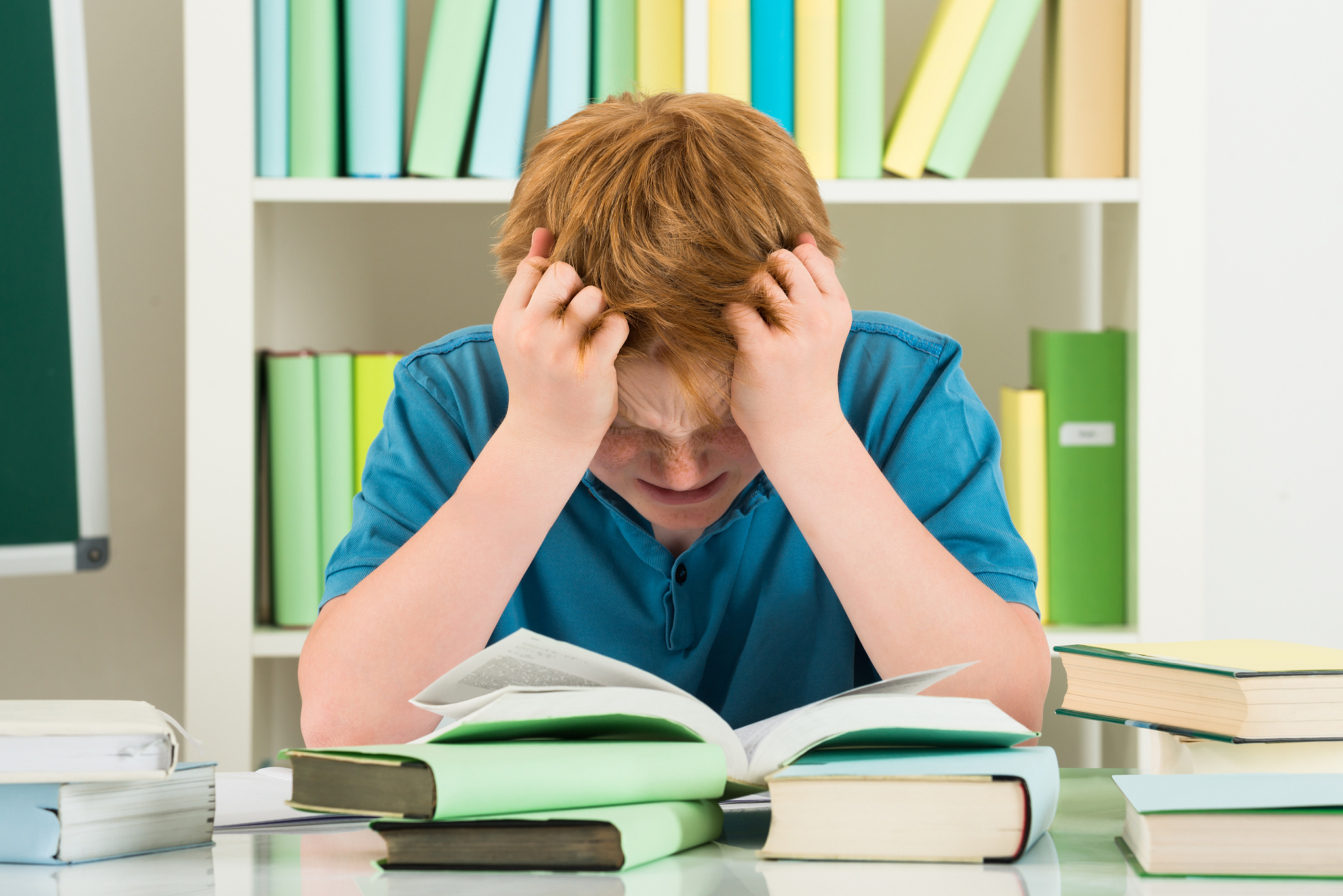 exhausted boy studying in library