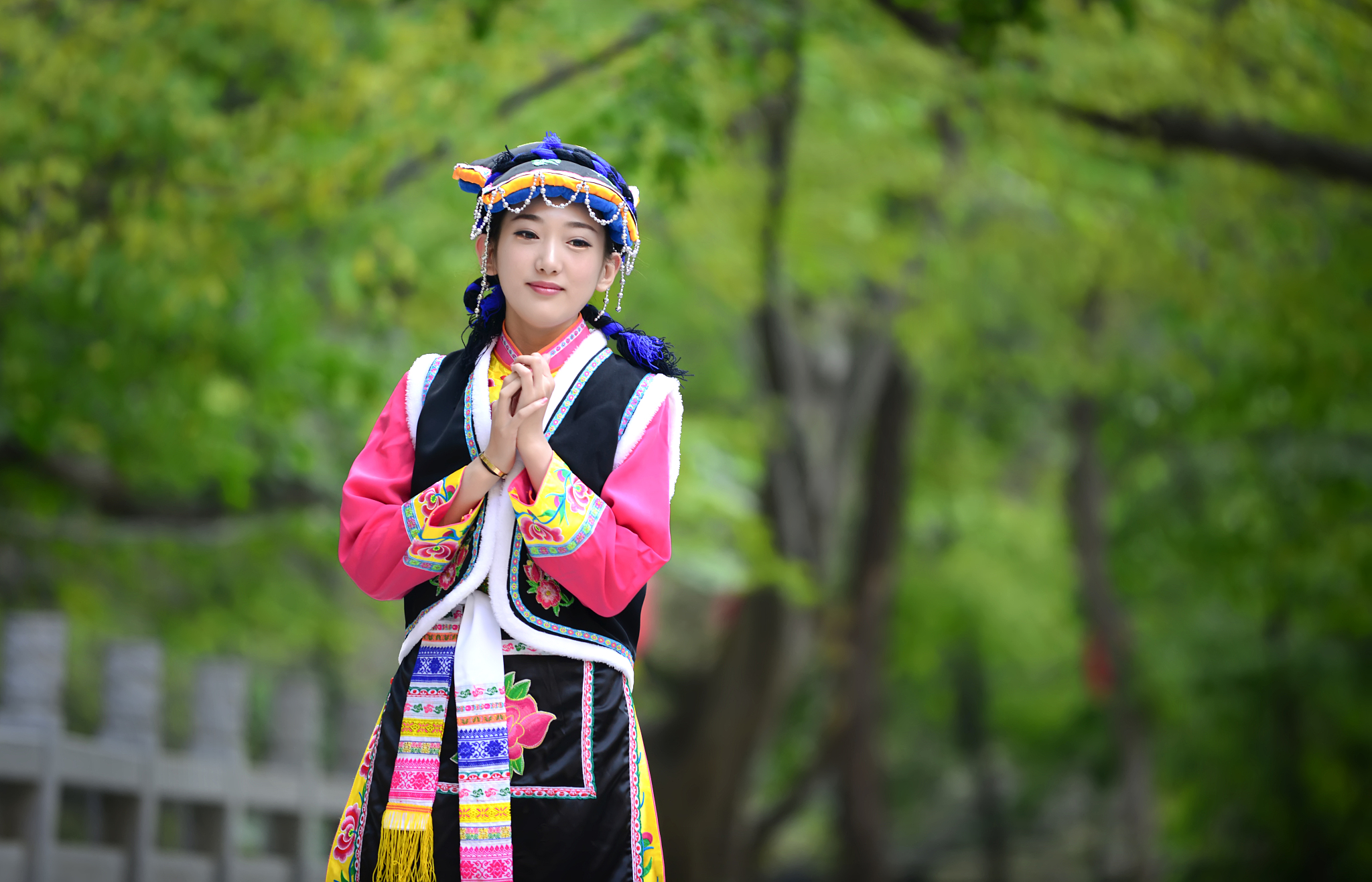 身穿少数民族服装的美女站在石桥上