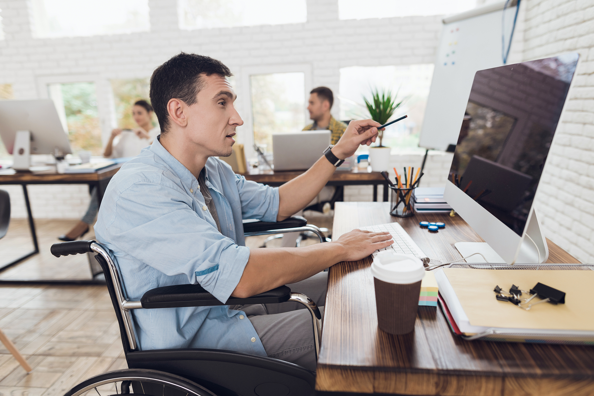 disabled person in the wheelchair looks carefully at the compute