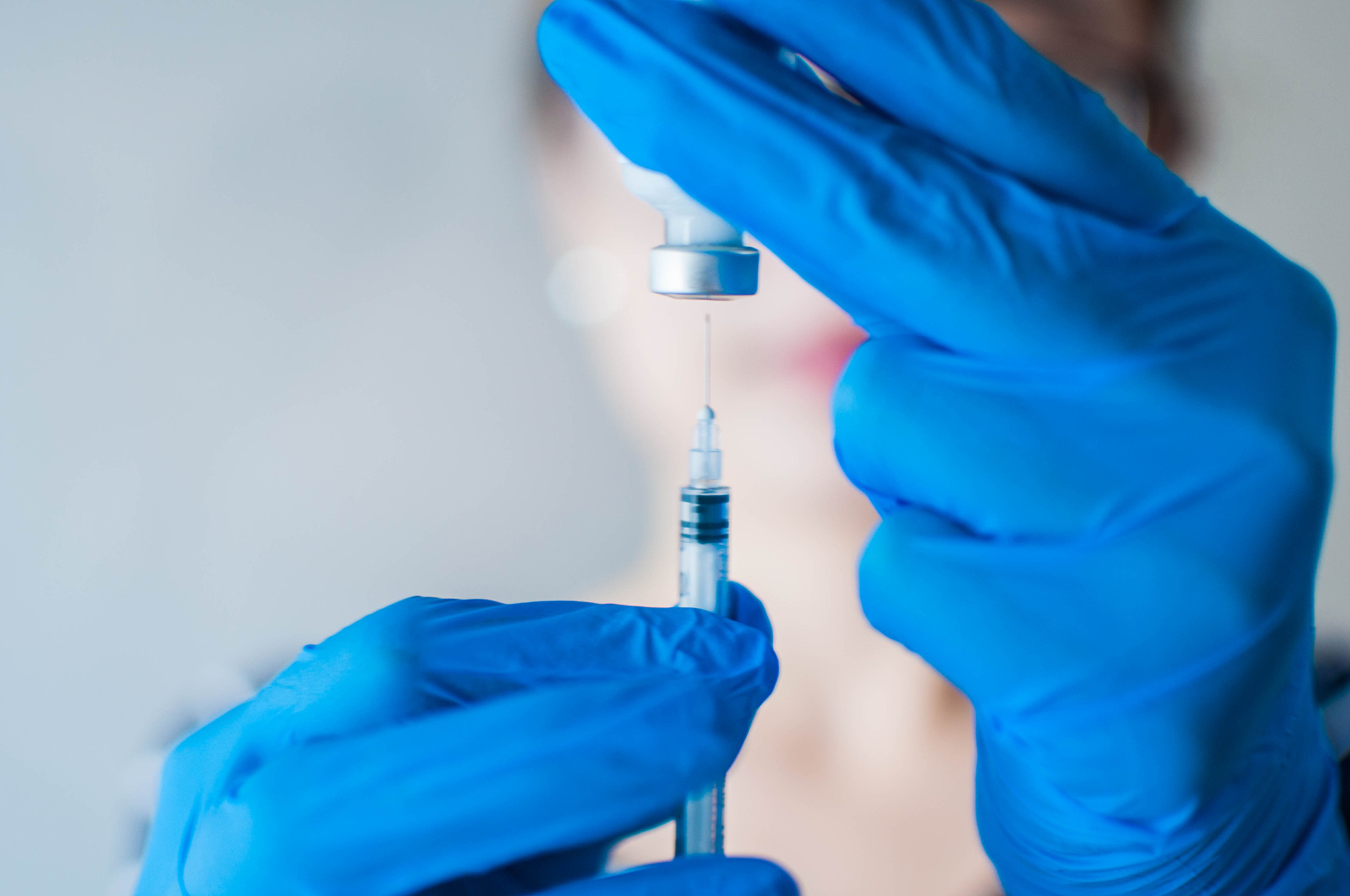 a young female doctor is holding a medical syringe and medicine 
