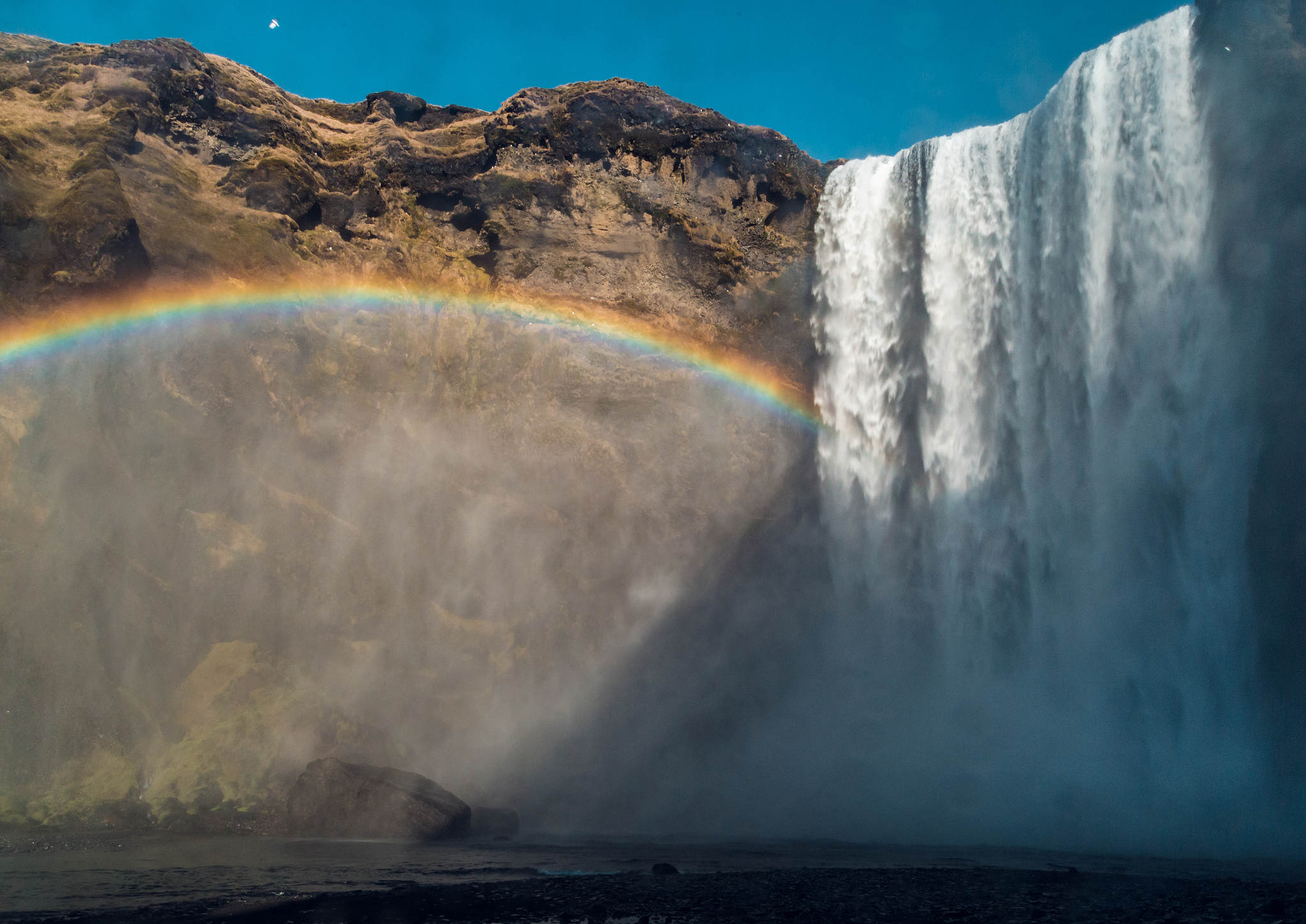 large waterfall in iceland with rainbow