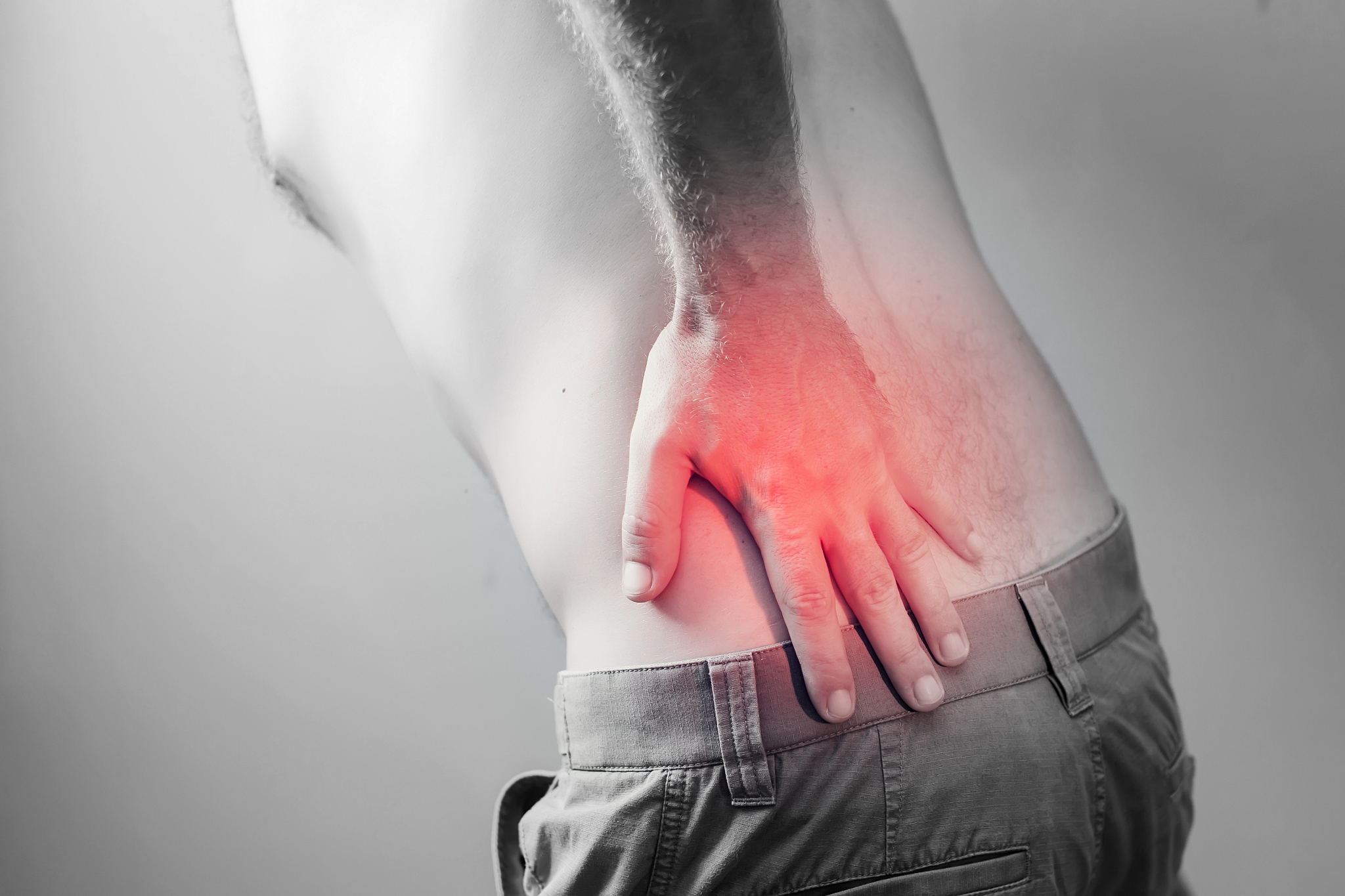 lumbago symptom. young man holding his painful inflamed loin. he