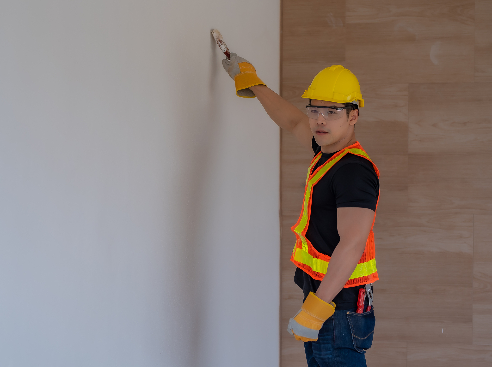 workers paint the walls with paint brushes.