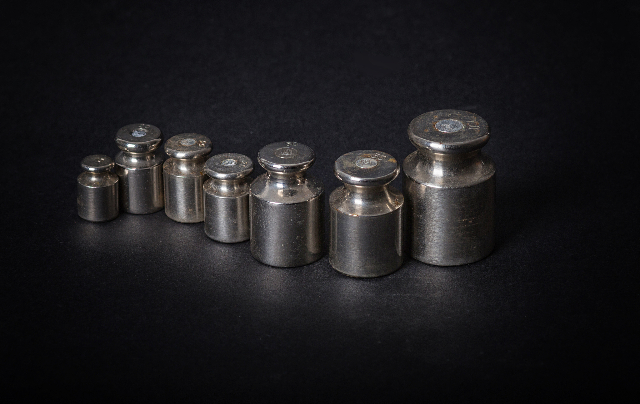 a set of small metal weights on a gray background