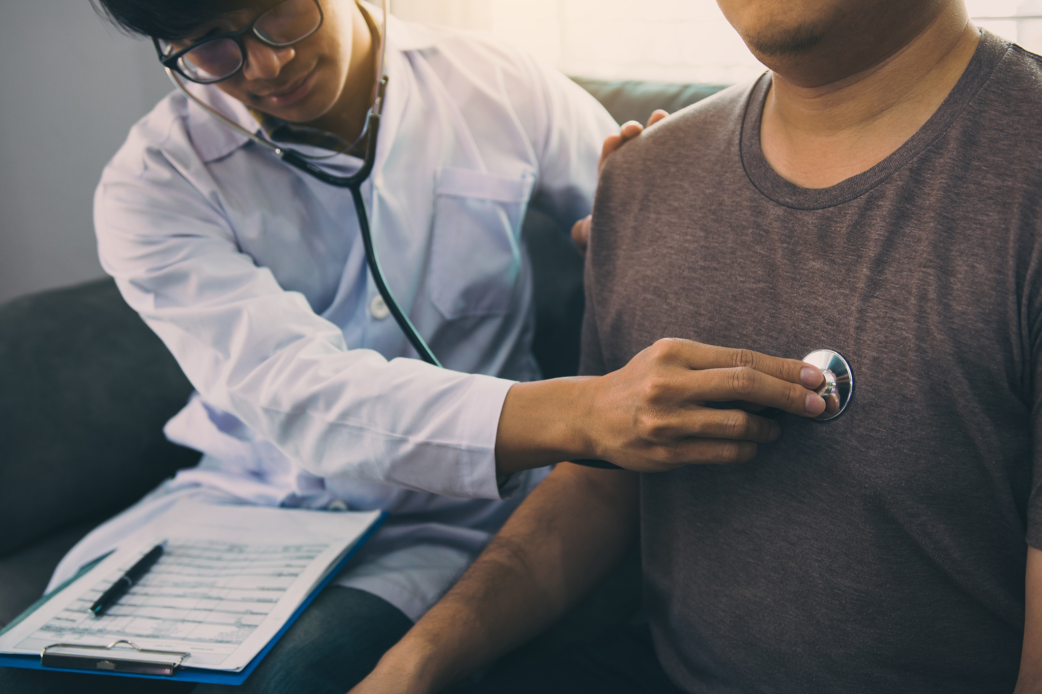 asian doctor is using a stethoscope listen to the heartbeat of t