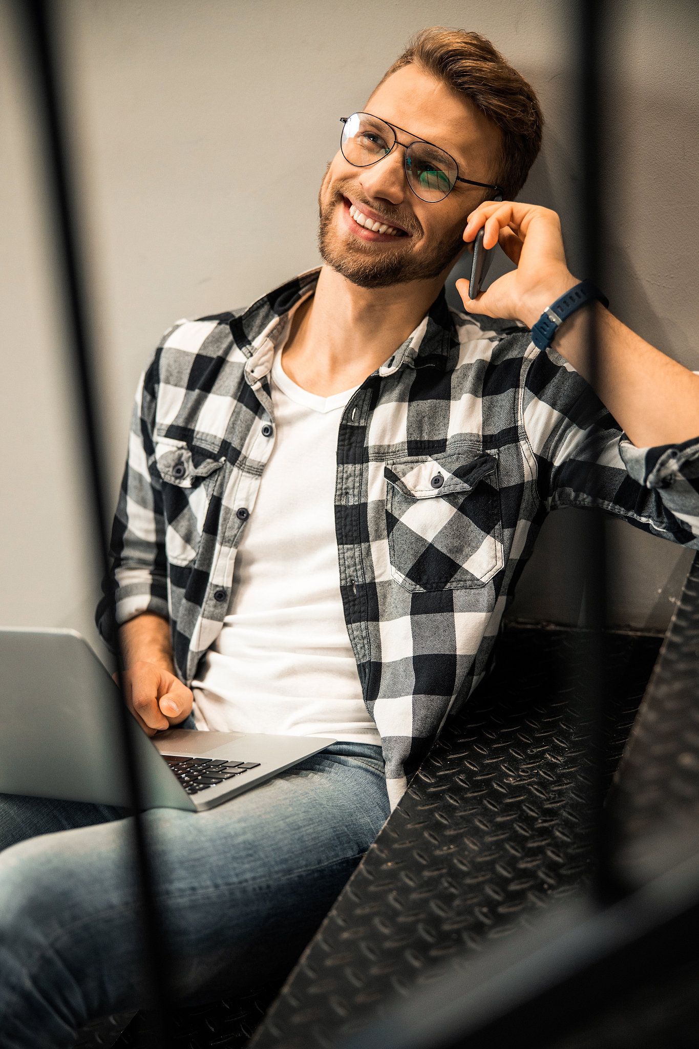 happy young male talking on smartphone while looking away