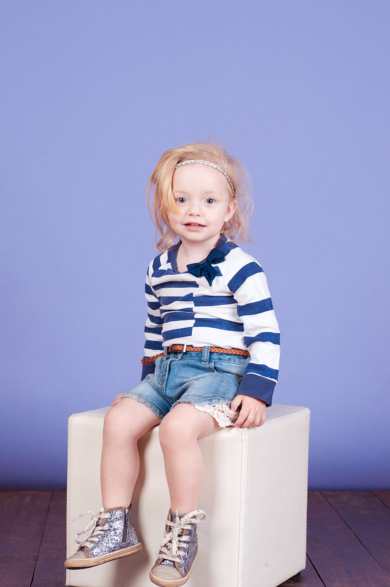 帮我撰写一篇时尚童装穿搭文案以描述服饰具体细节为主题服装类型：蓝色小裙子黄色印花蔓延、黄色波浪条纹叠加在浅黄的T恤造型、无袖宽松连衣裙趣味小兔子印花装点