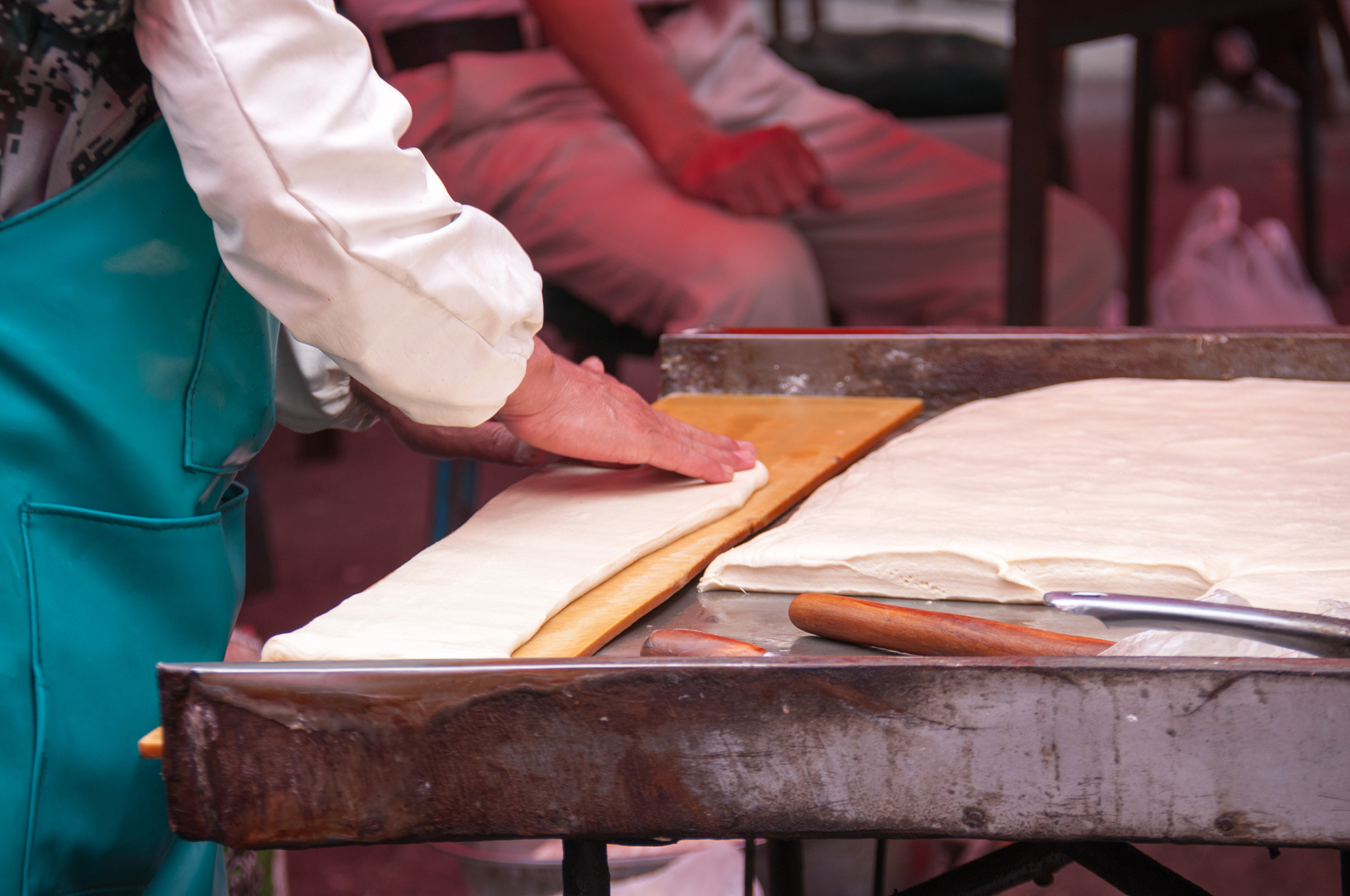 china, heihe, july 2019: a woman rolls dough at the market