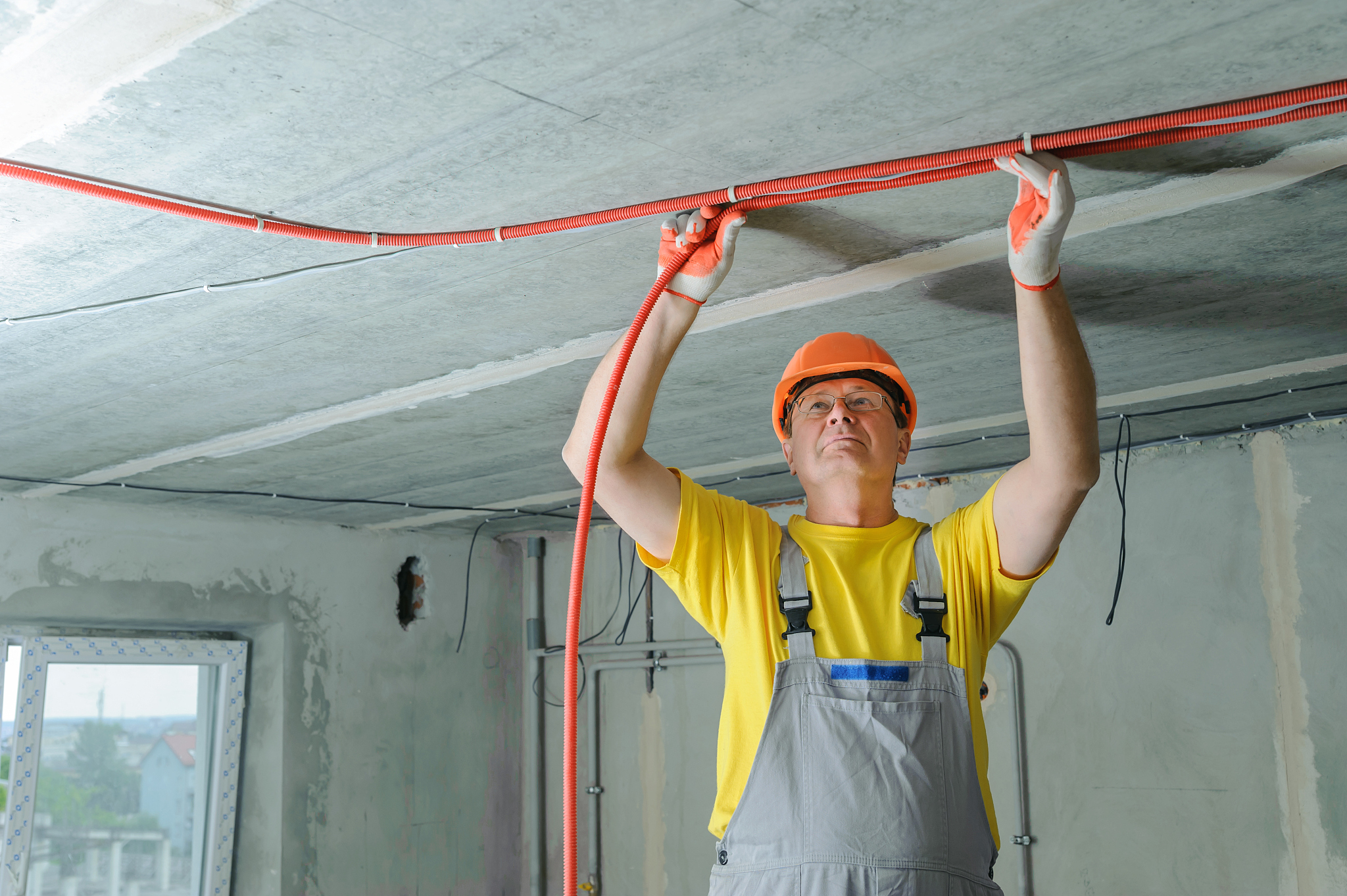 an electrician is fixing an electric corrugated tube.