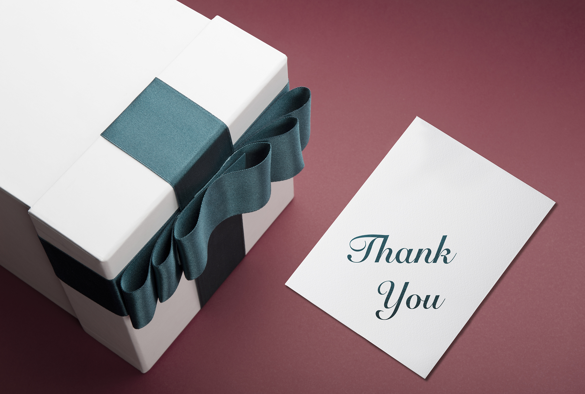 white gift box and thank you note on red background.