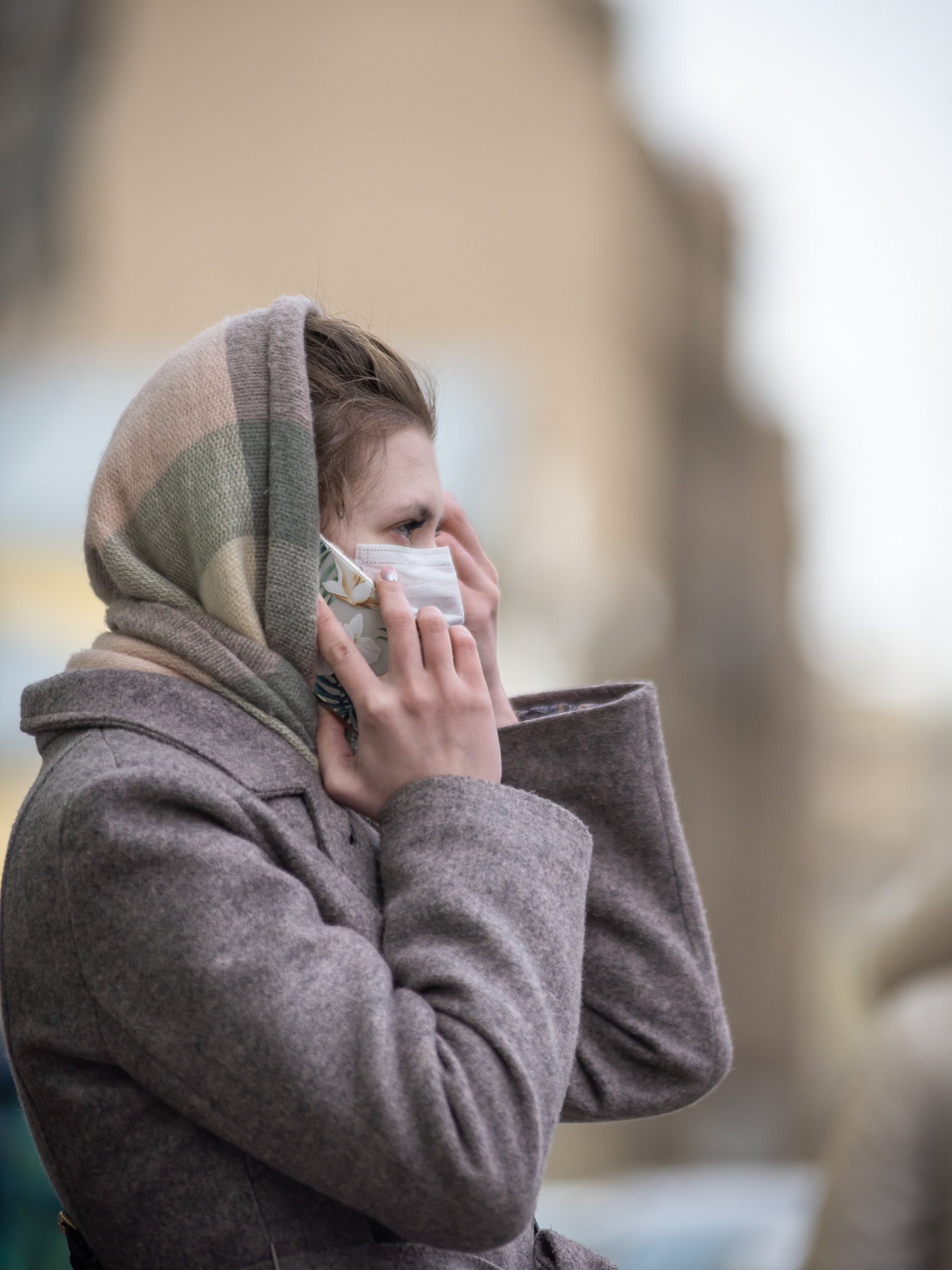 young attractive woman in a medical protective mask is talking o
