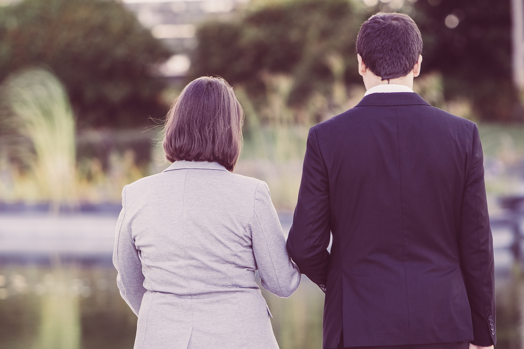 back view of business people walking near pond