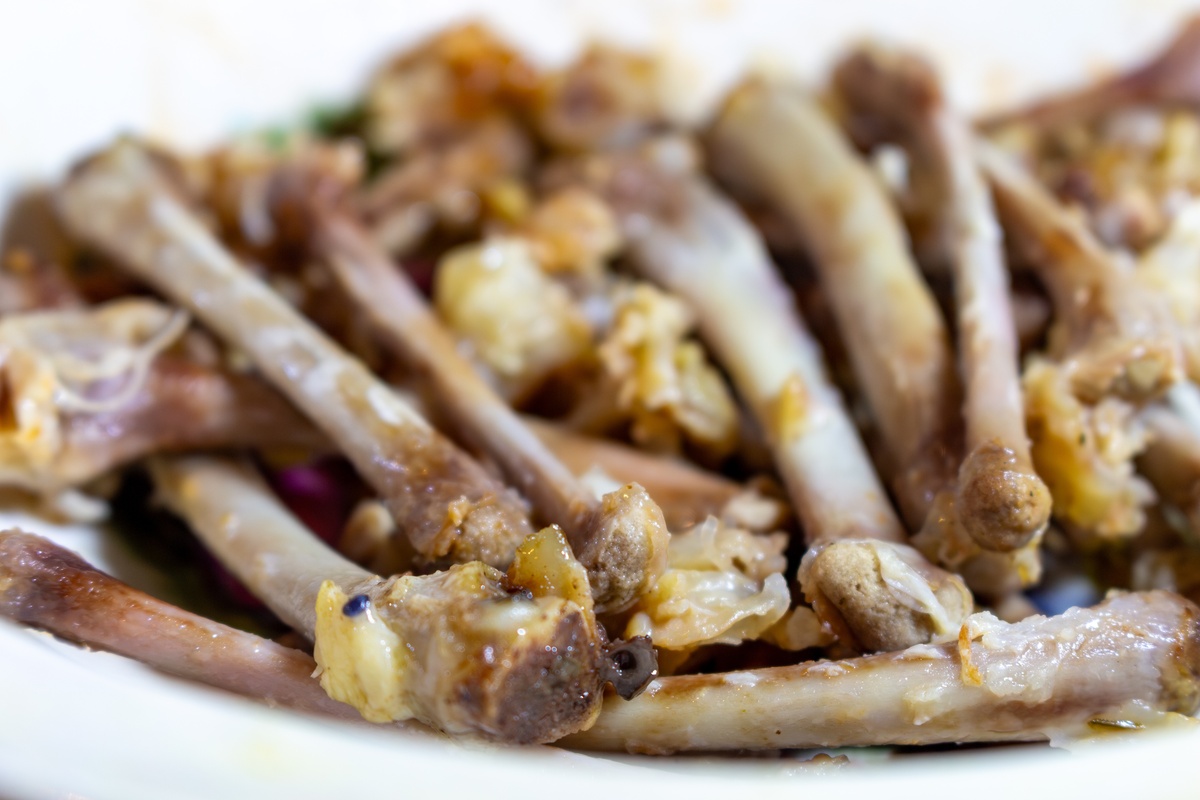 一盘美味的炸鸡骨,配以香料和香草,盛在白盘中