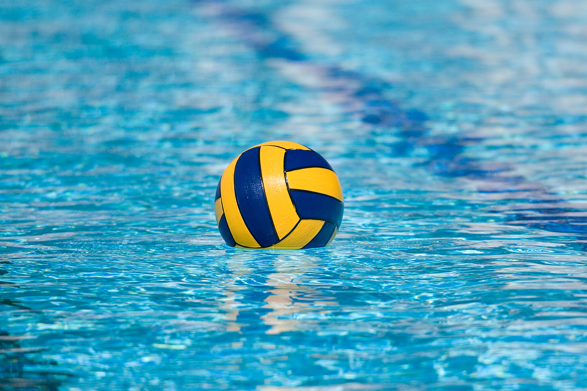 a yellow and blue ball floating in a pool