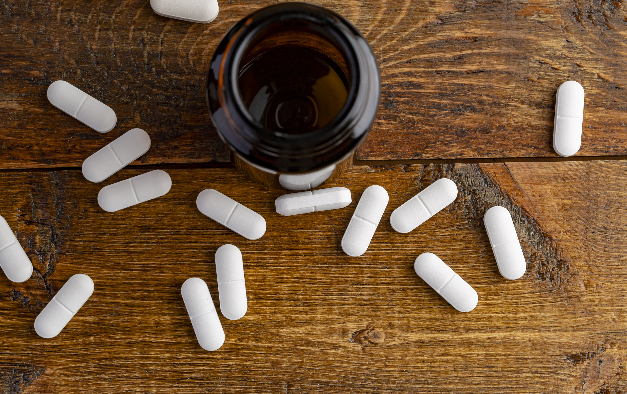 one glass pills bottle and white pills
