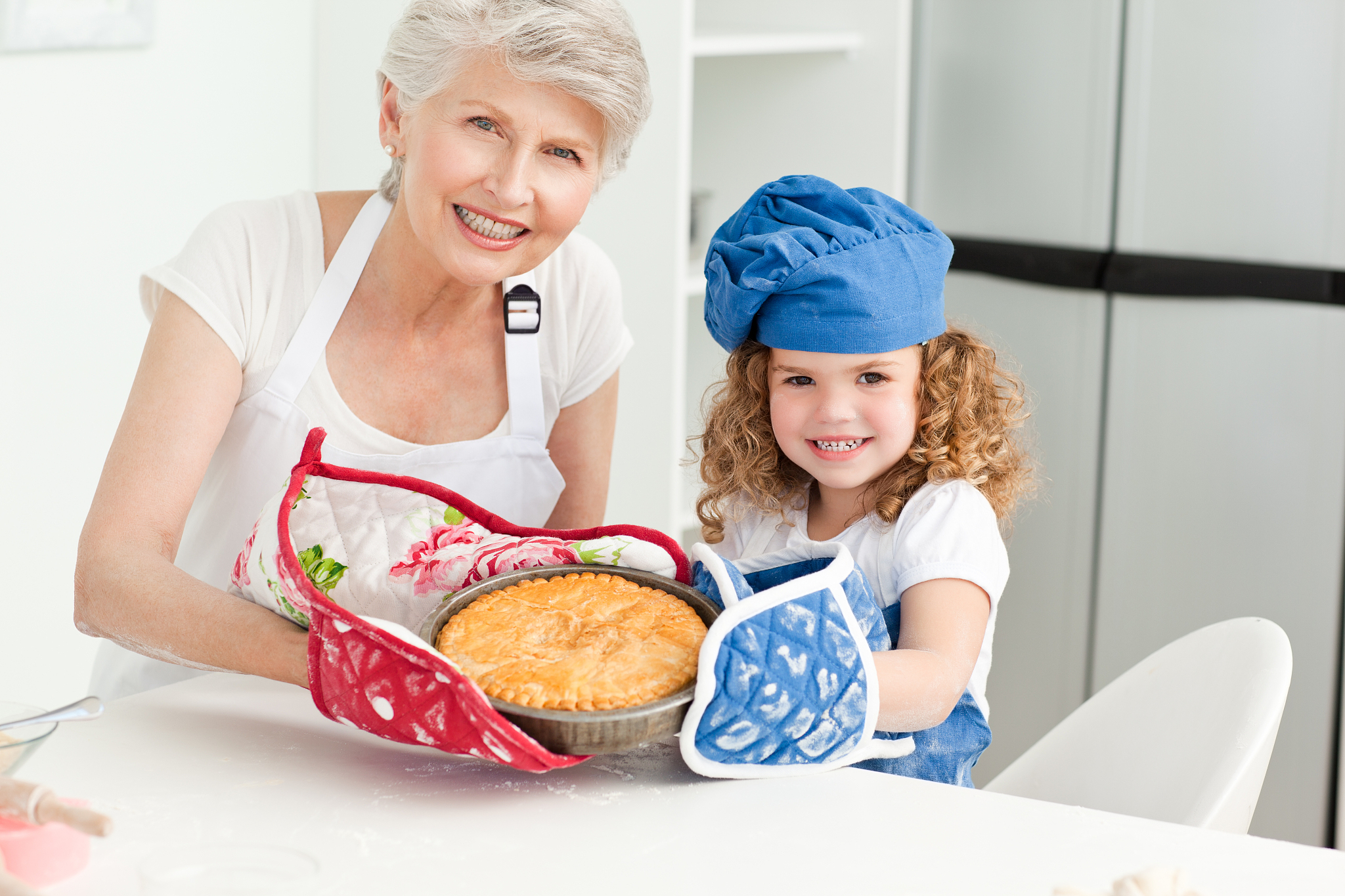 a little girl with her grandmother looking at the camera at home