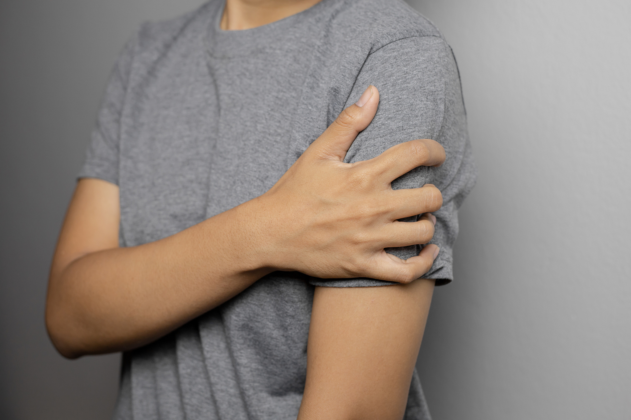 woman suffering from pain in arm.