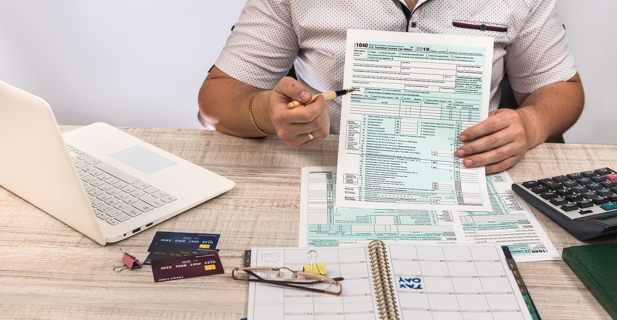 man filling 1040 tax form at workplace. performing tax calculati