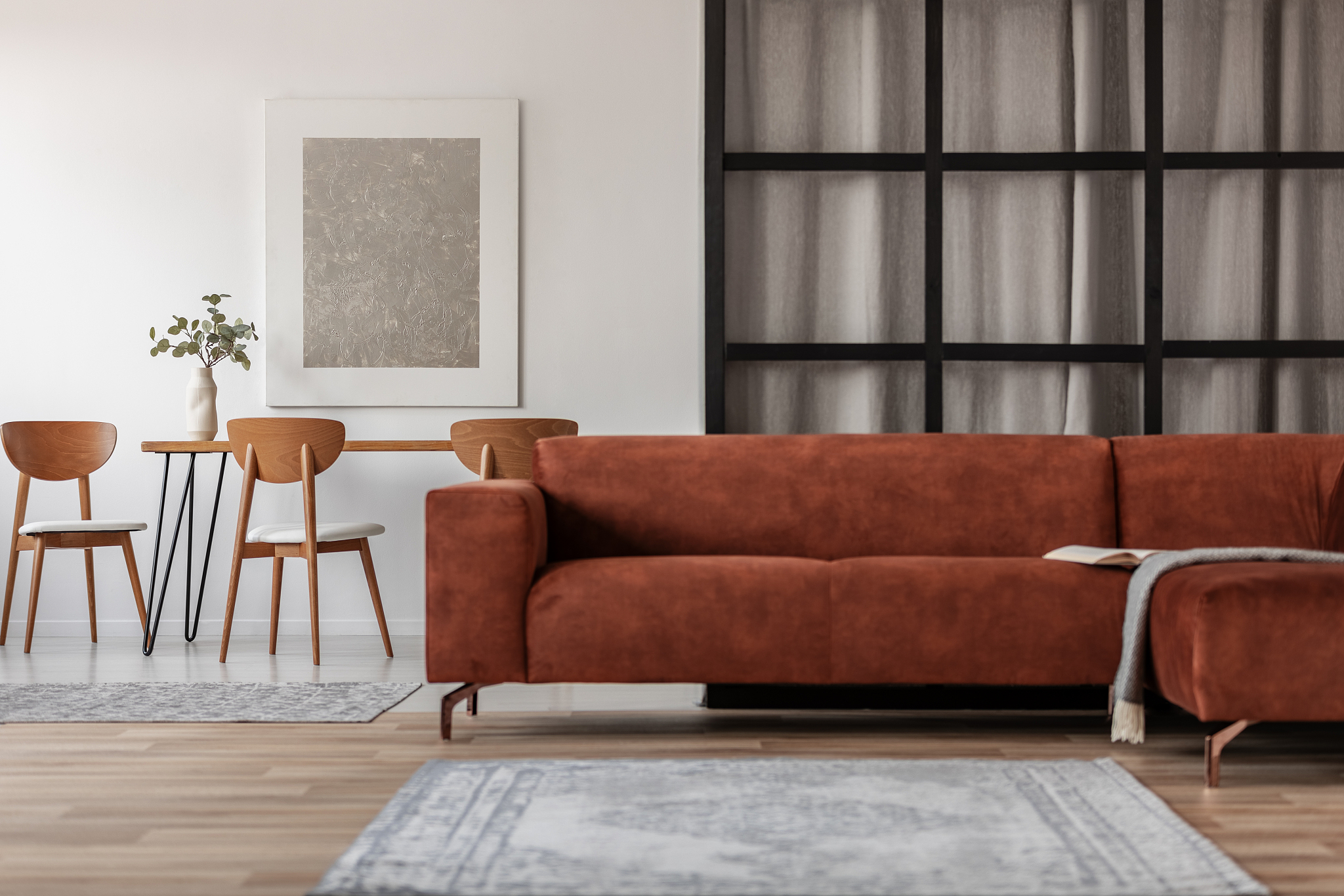 stylish corner sofa in open space studio apartment with dining a