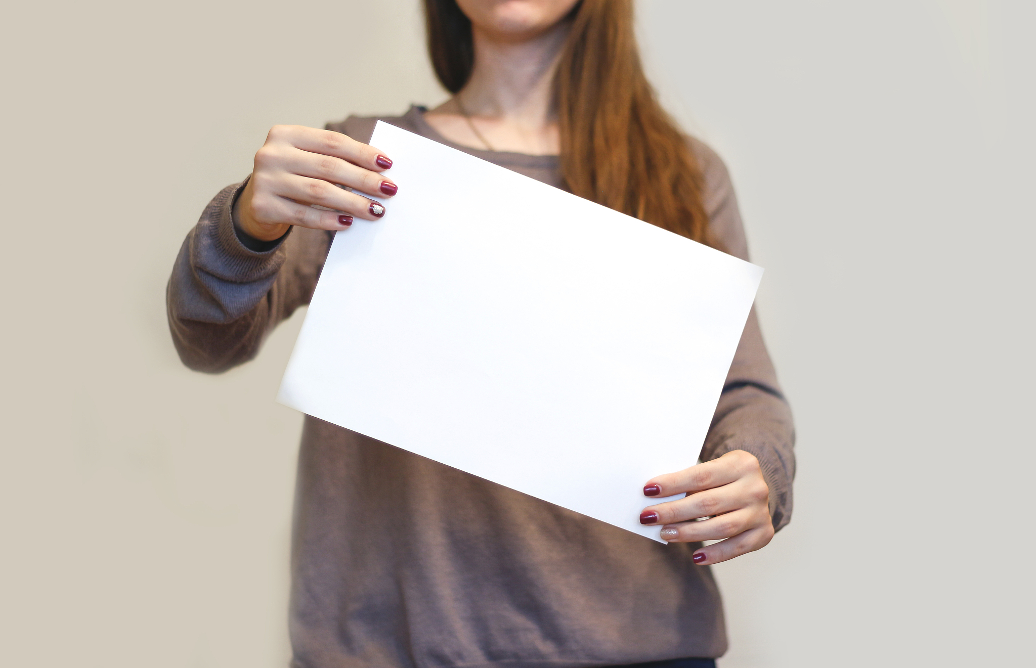 girl holding aslant white a4 blank paper. leaflet presentation. 
