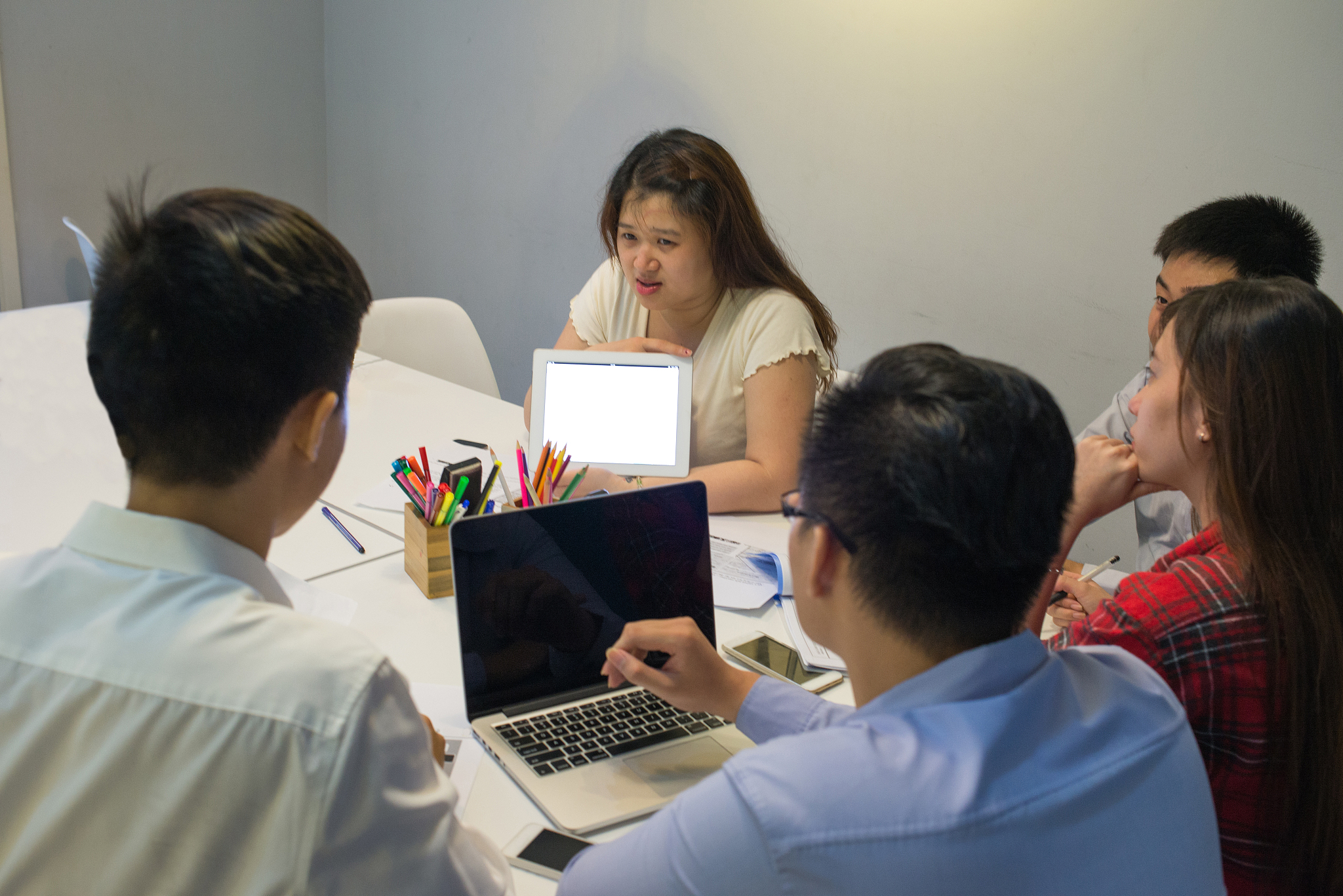 business woman asking her workmates about the problem in tablet