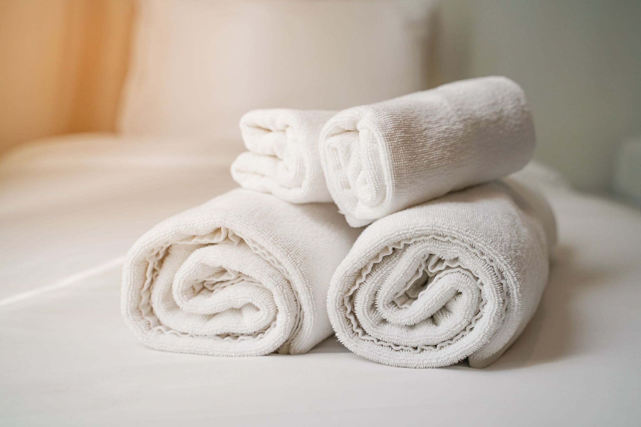 white fluffy towels on bed for hotel customer