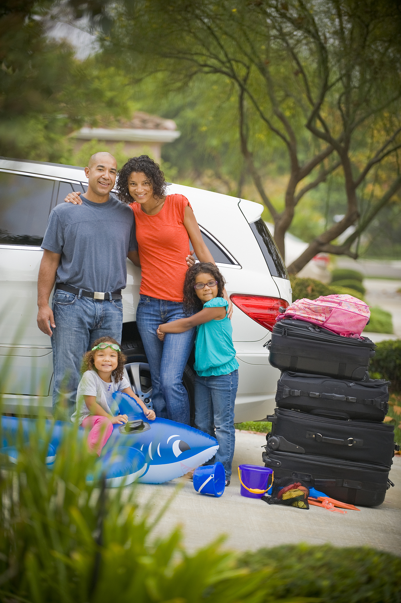 family in their driveway packing for vacation