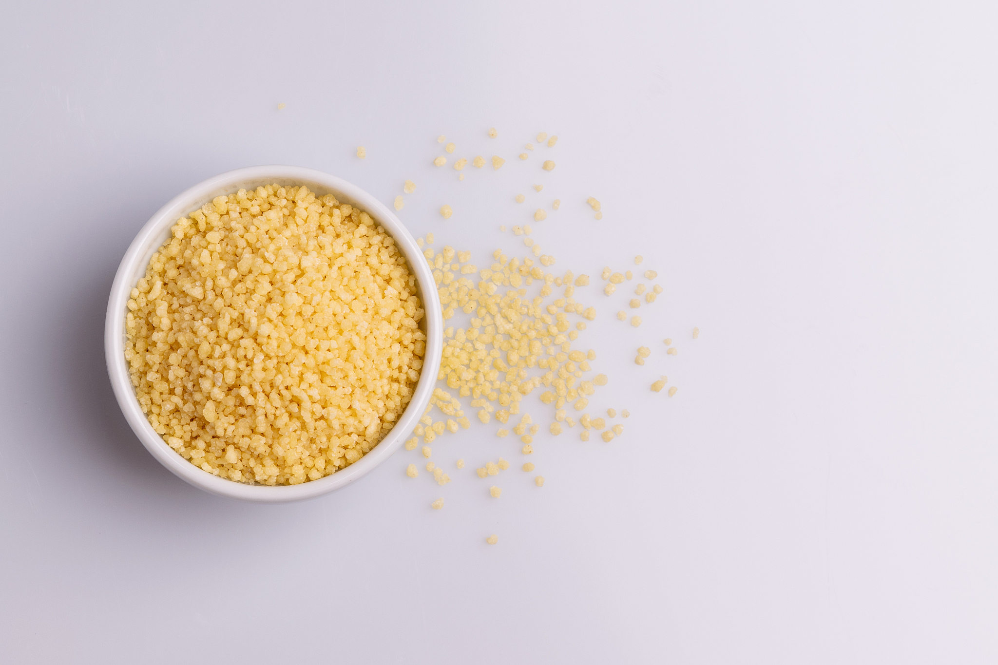 dry couscous isolated on white background, soft light, copy spac