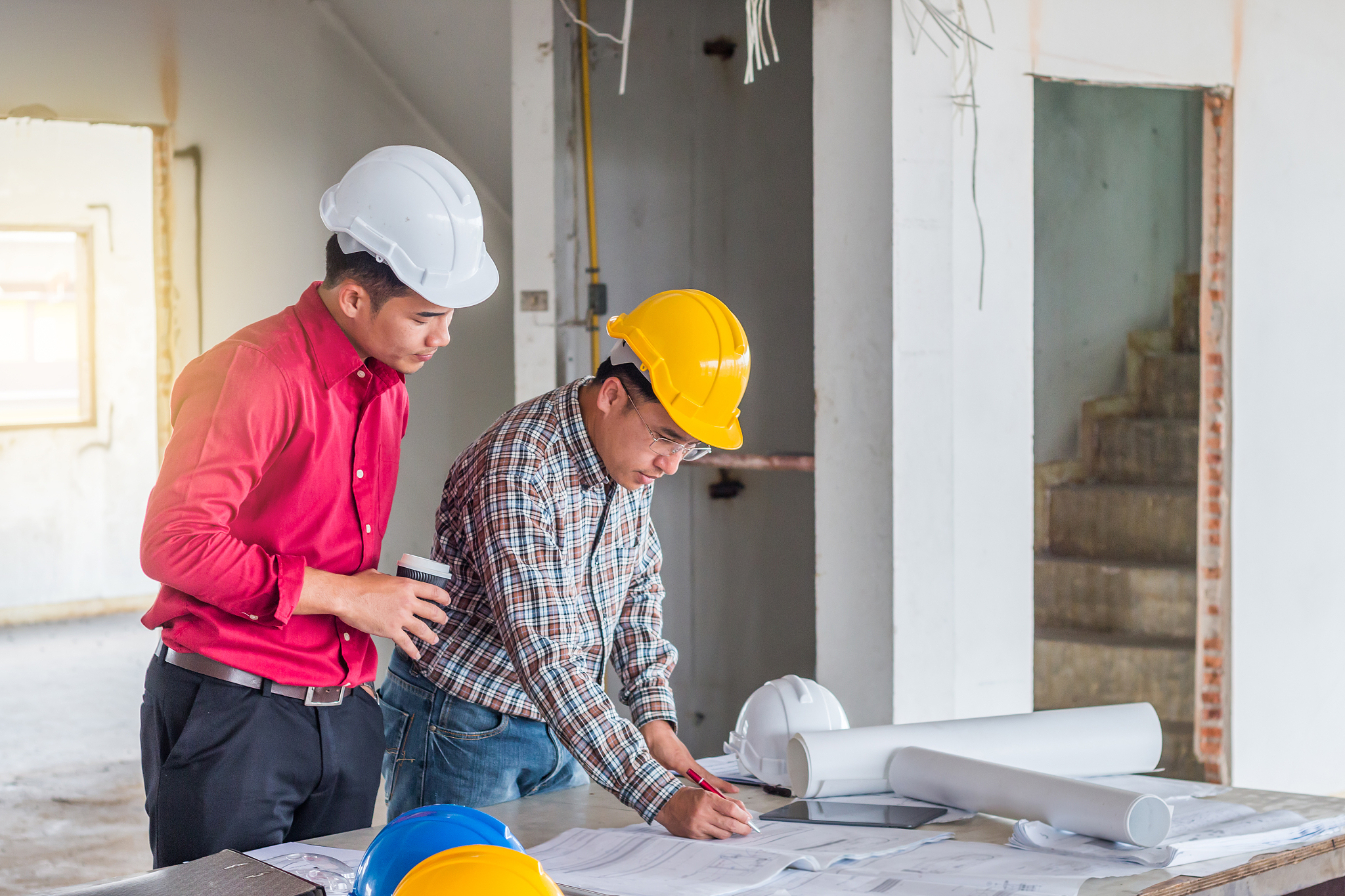 architects analyzing blueprint on table at construction site