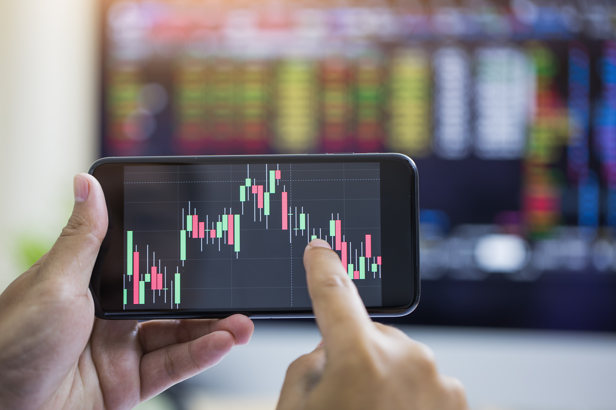 businessman checking stock market data. he using a mobile phone.