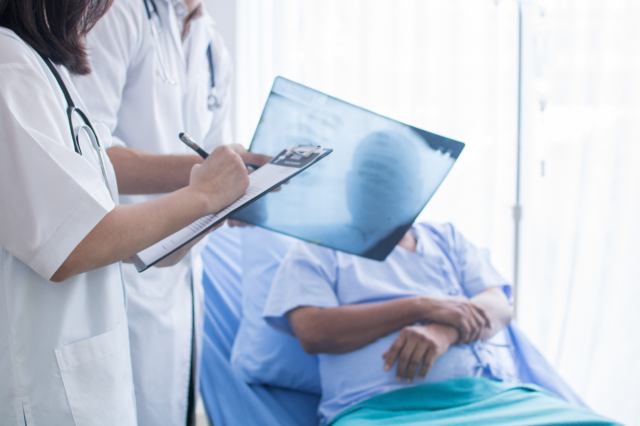 midsection of doctors discussing medical record while standing b