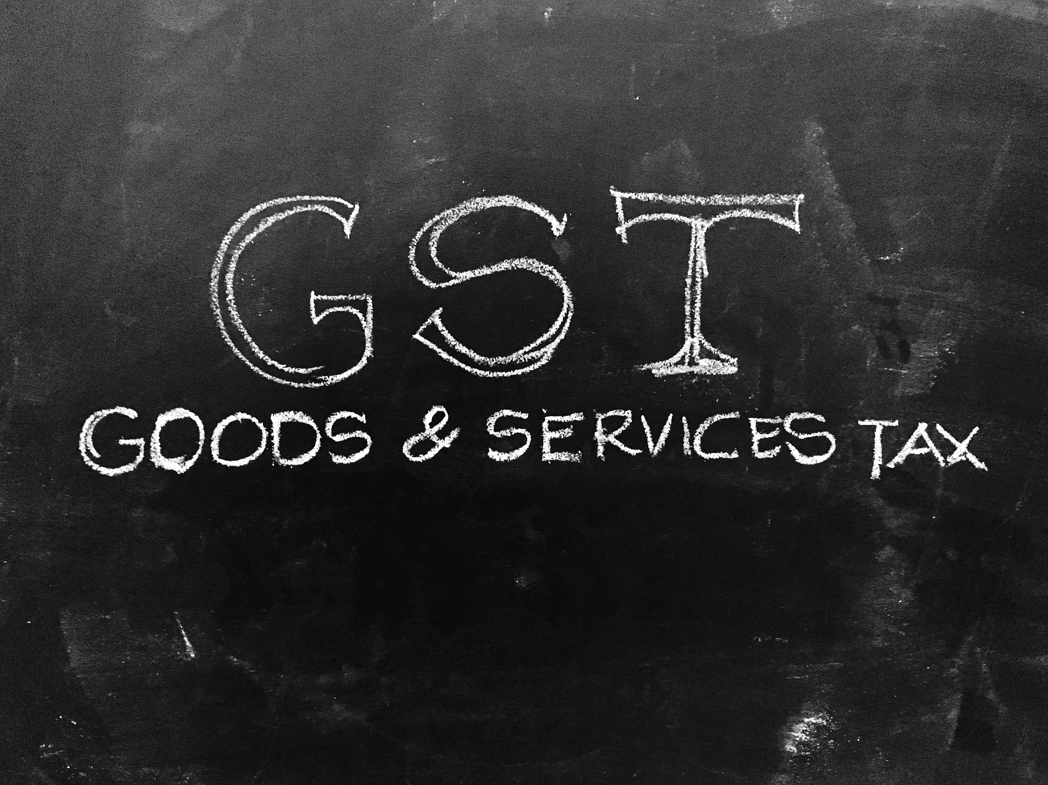 goods & services tax - gst - handwritten on blackboard - stock i